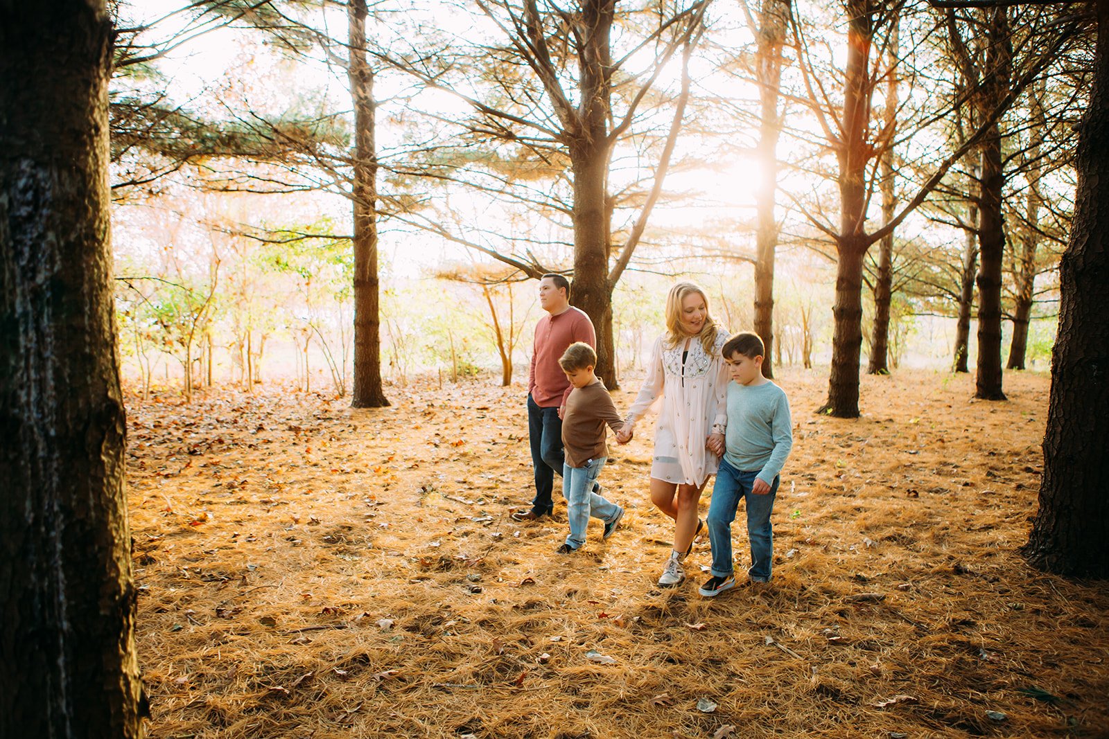  A family holding hands are walking through a forest in the winter in Illinois with Teala Ward Photography. winter family pictures #TealaWardPhotography #TealaWardFamilies #holidayfamilypics #photography #Illinoisfamilyphotography #familysession 