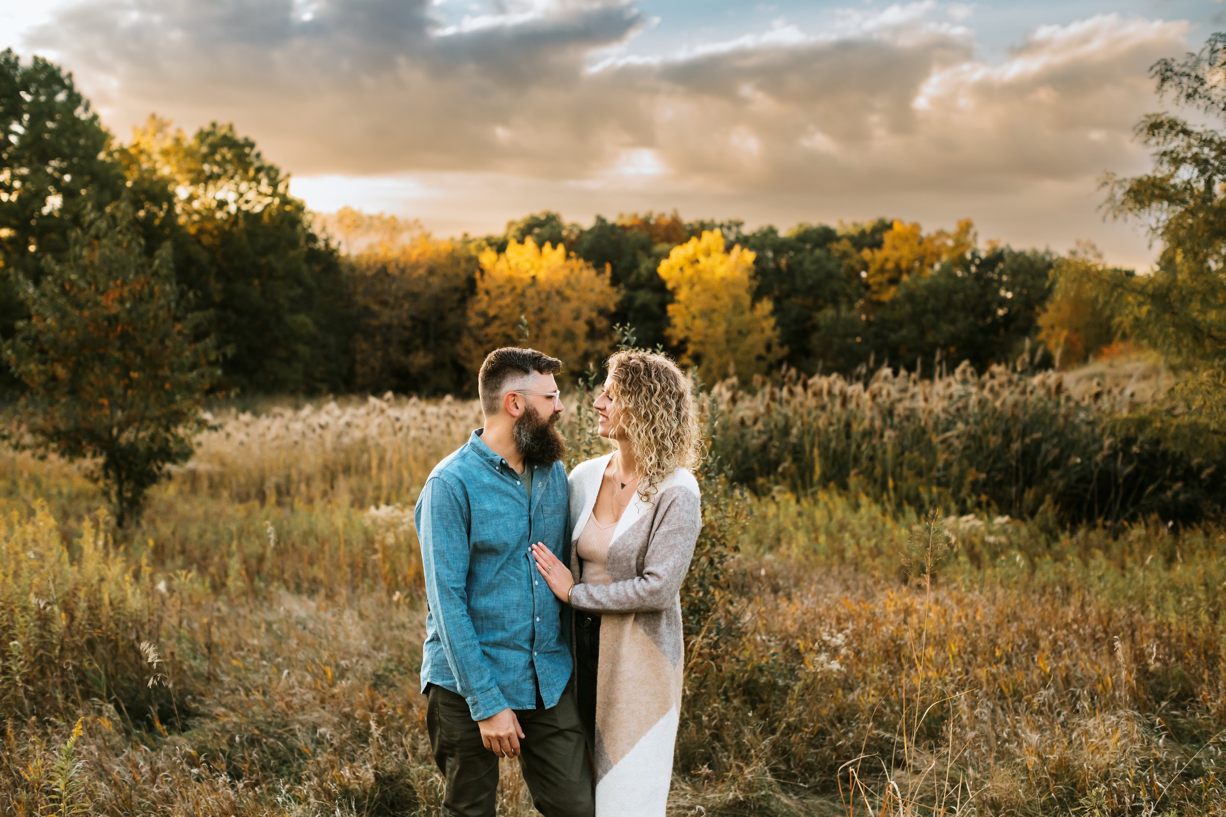  Family photographer Teala Ward Photography captures the sun setting behind a man and woman looking at one another. boho fam pic #TealaWardPhotography #TealaWardFamilies #IllinoisValleyfamilypics #fursibiling #Illinoisfamilyphotography #brother&amp;s