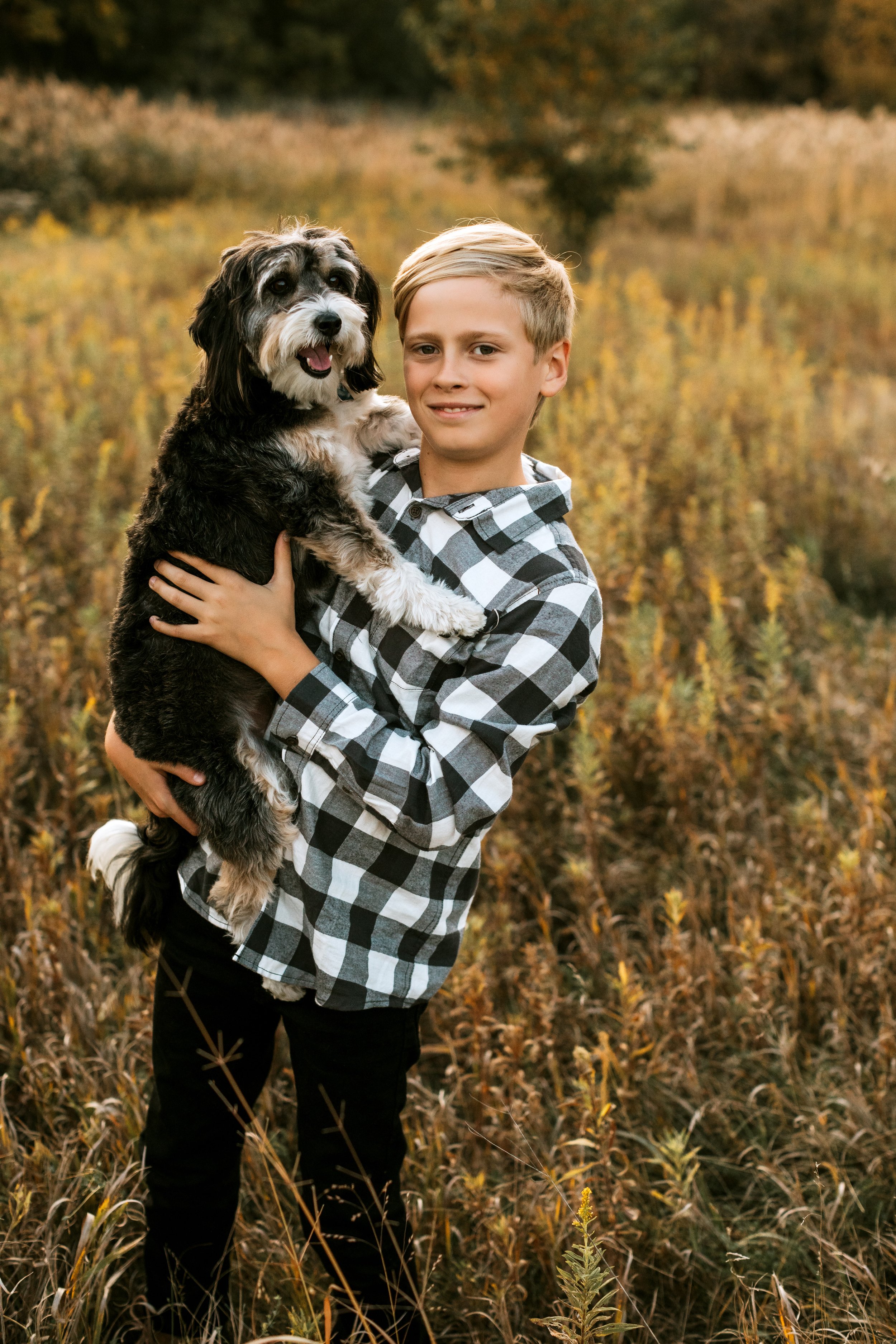  A little black fur sibling smiles with his human brother by Teala Ward Photography. fur siblings with humans #TealaWardPhotography #TealaWardFamilies #IllinoisValleyfamilypics #fursibiling #Illinoisfamilyphotography #brother&amp;sister 