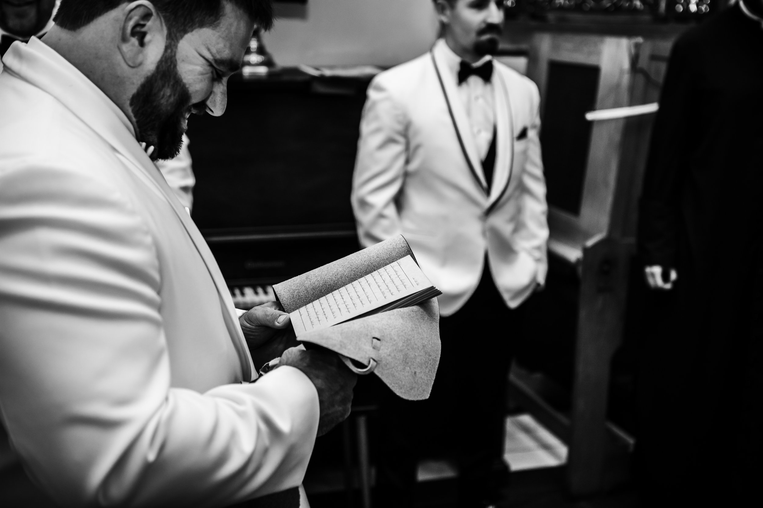  Teala Ward Photography captures a groom reading his vows on his wedding day in a historic building in LaSalle. groom candids #TealaWardPhotography #TealaWardWeddings #LaSalleWedding #churchwedding #Illinoisweddingphotographer #LaSalle,IL 
