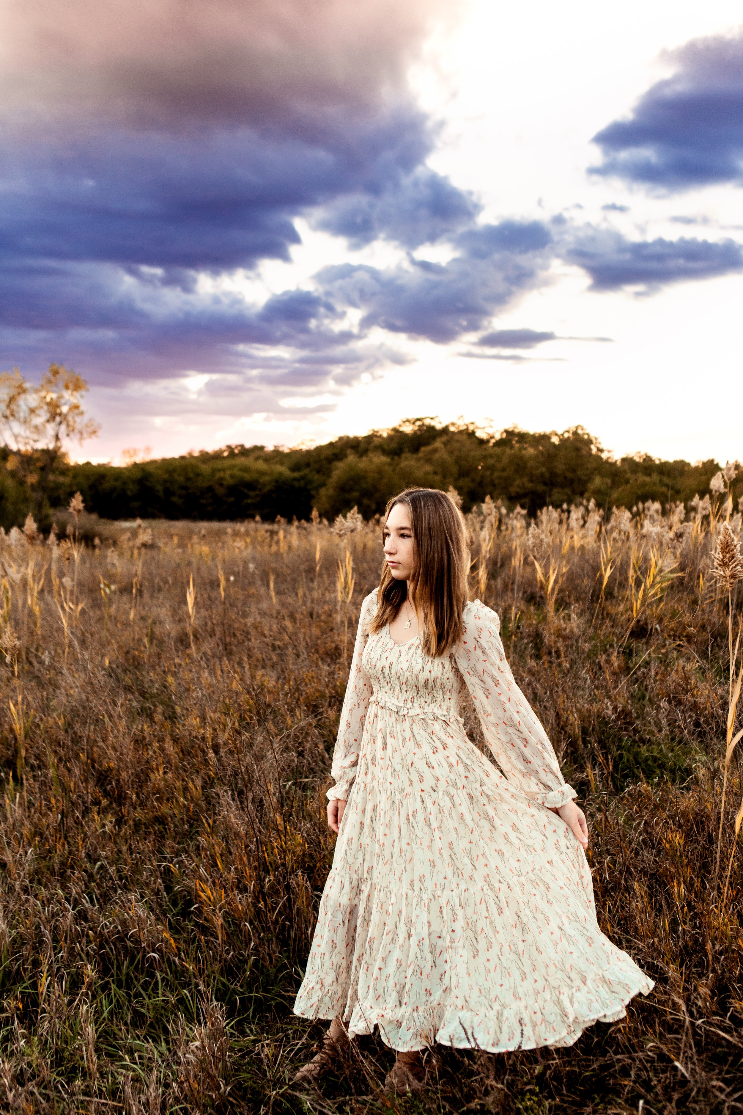  Teala Ward Photography captures a teenage girl twirling in a field at sunset with a stunning sky. teenage girl outfits #TealaWardPhotography #TealaWardFamilies #photographers #IllinoisPhotographer #ILphotographers #IllinoisValleyFamilies 