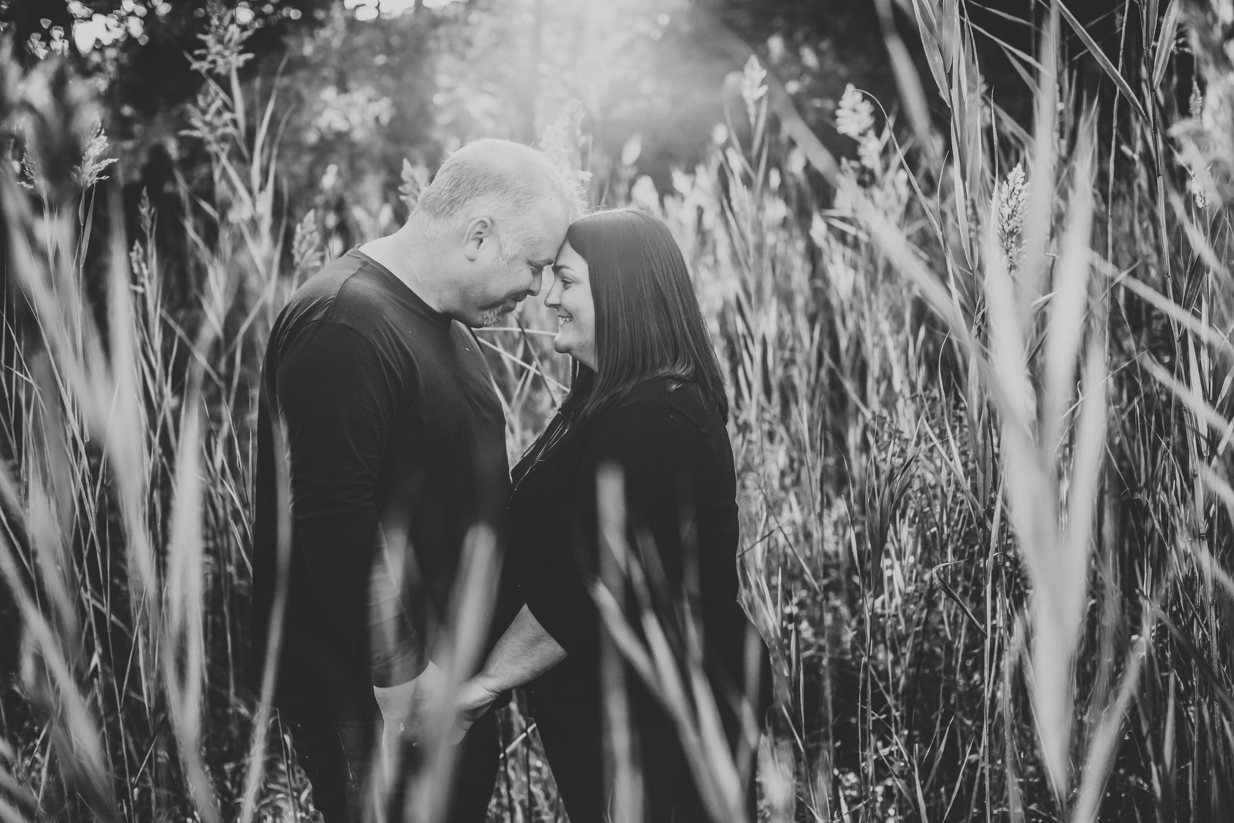  Illinois family photographer Teala Ward Photography captures a black and white portrait of a mother and father snuggling. tall grass family portraits Illinois Family Sessions #TealaWardPhotography #TealaWardFamilies #Outdoorfamilyportraits #Illinois