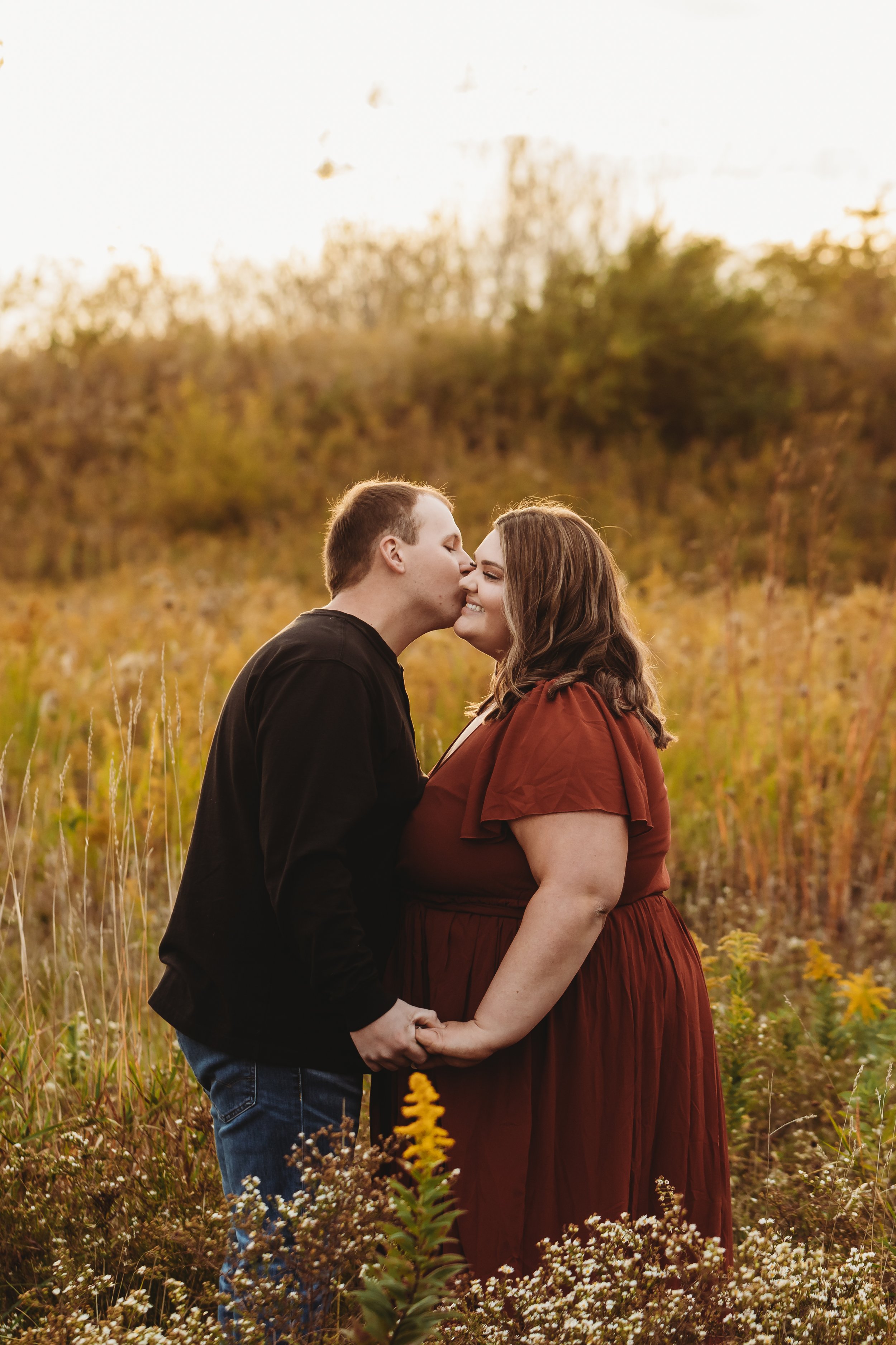  A couple kisses in a yellow field in Illinois during their engagement session with Teala Ward Photography. warm weather engagements in Illinois wedding photo tips and tricks #TealaWardPhotography #TealaWardEngagements #Weddingphotographer #ILwedding