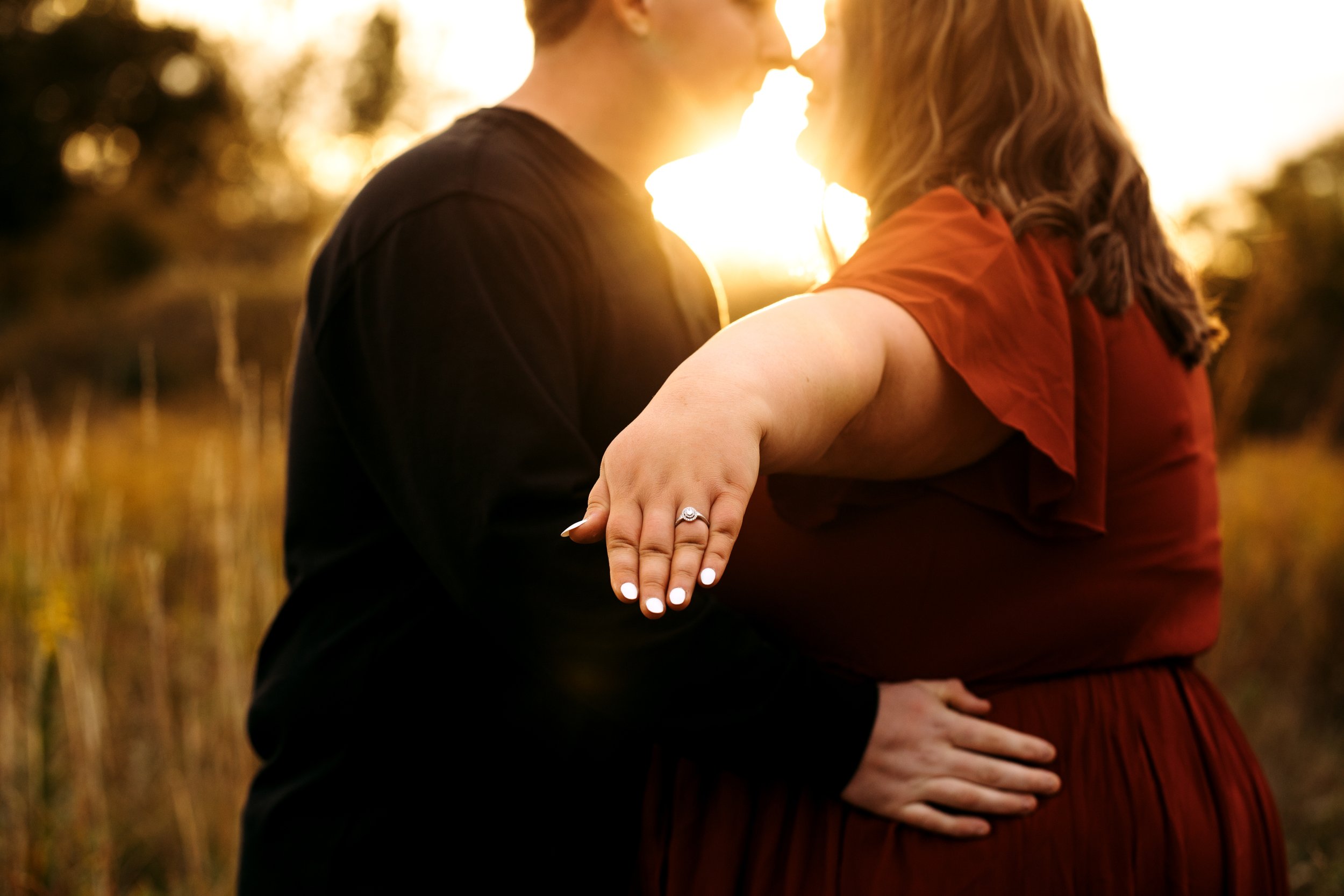  A sunburst between a man and woman kissing during an engagement with the bride showcasing the ring by Teala Ward Photography. sunburst kiss wedding ring picture #TealaWardPhotography #TealaWardEngagements #Weddingphotographer #ILweddings #Weddingeng