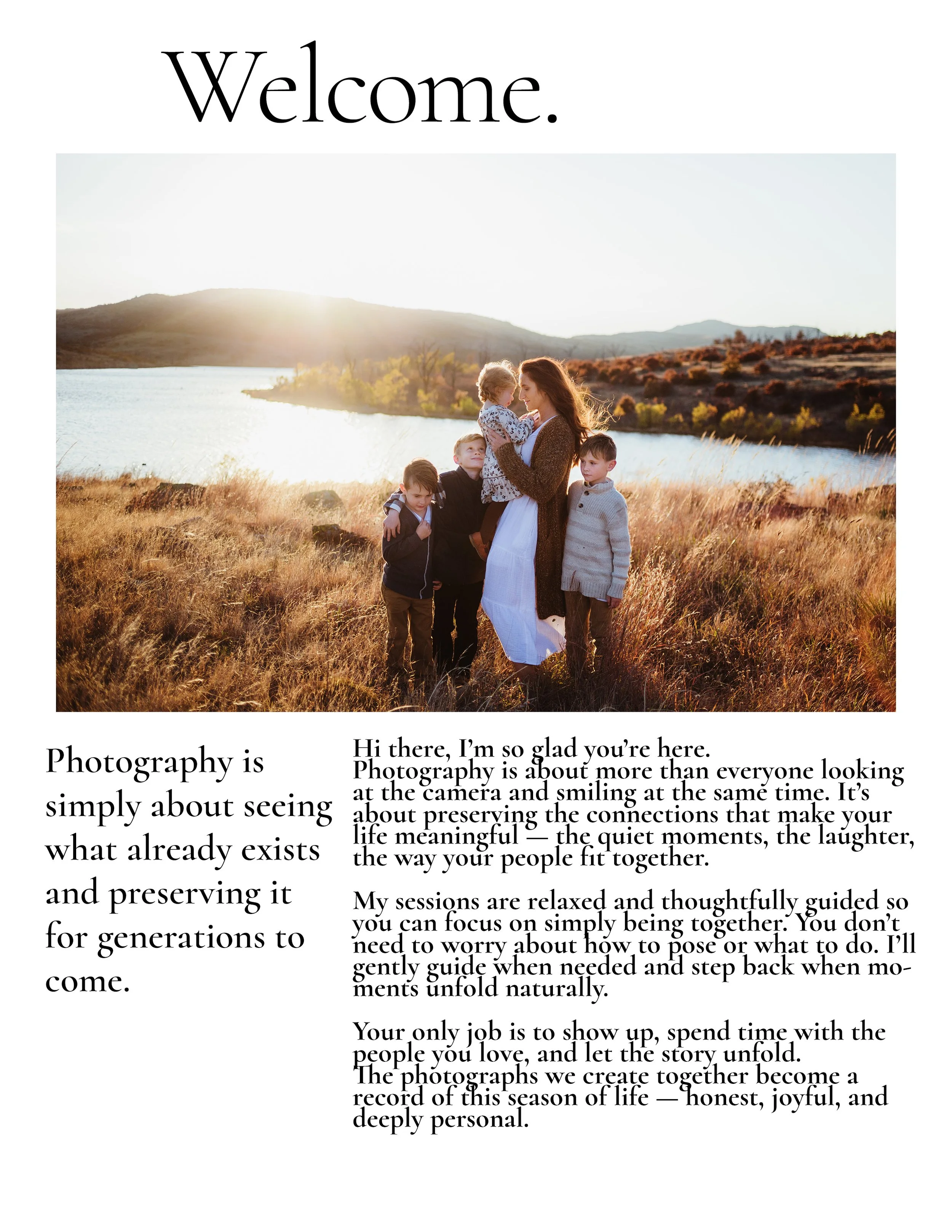 A woman and five children standing together in a golden field near a body of water, with hills and a setting sun in the background.