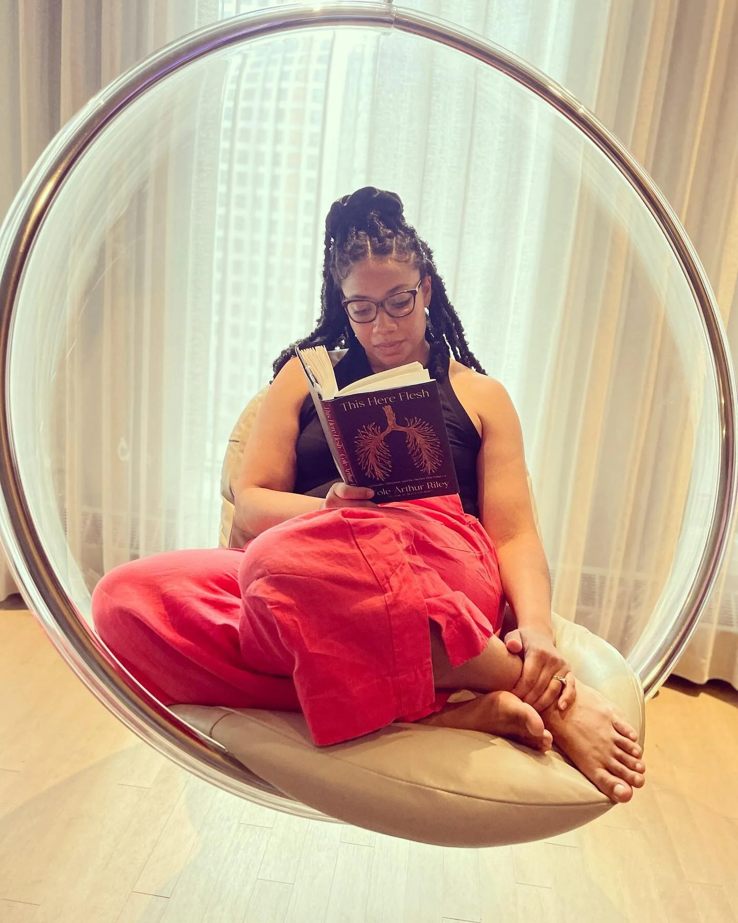 ✨ currently reading ✨

This book is a balm. Cannot recommend more highly&hellip;and I&rsquo;m only on page 42!
✨
[ID: Genay, wearing glasses, salmon pants, and bare feet, in a delightful clear round hanging bubble chair, reading &ldquo;This Here Fles
