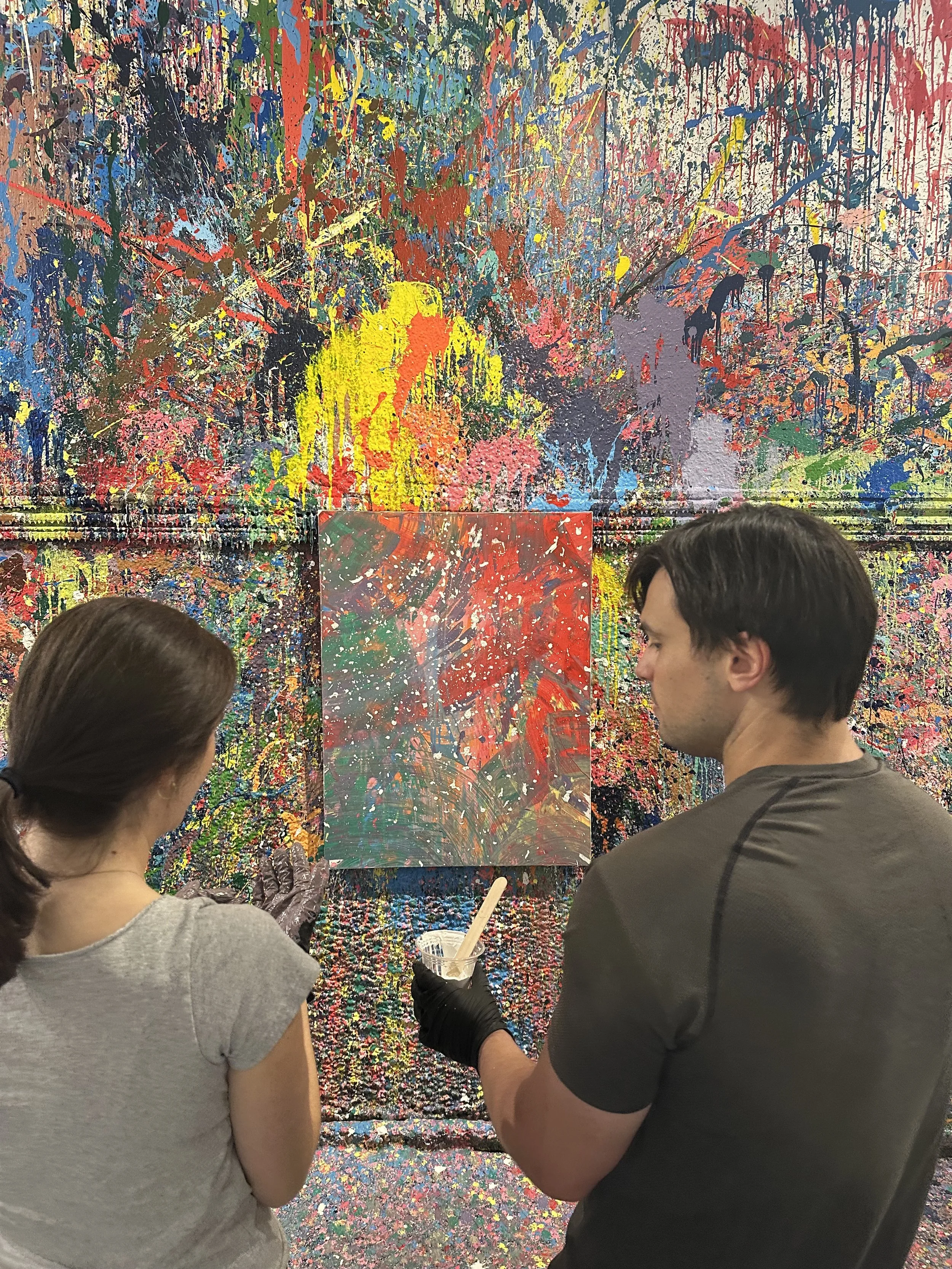 A couple deliberates over the direction to take their artwork that they are making together during a date night at Splatter Charlotte.