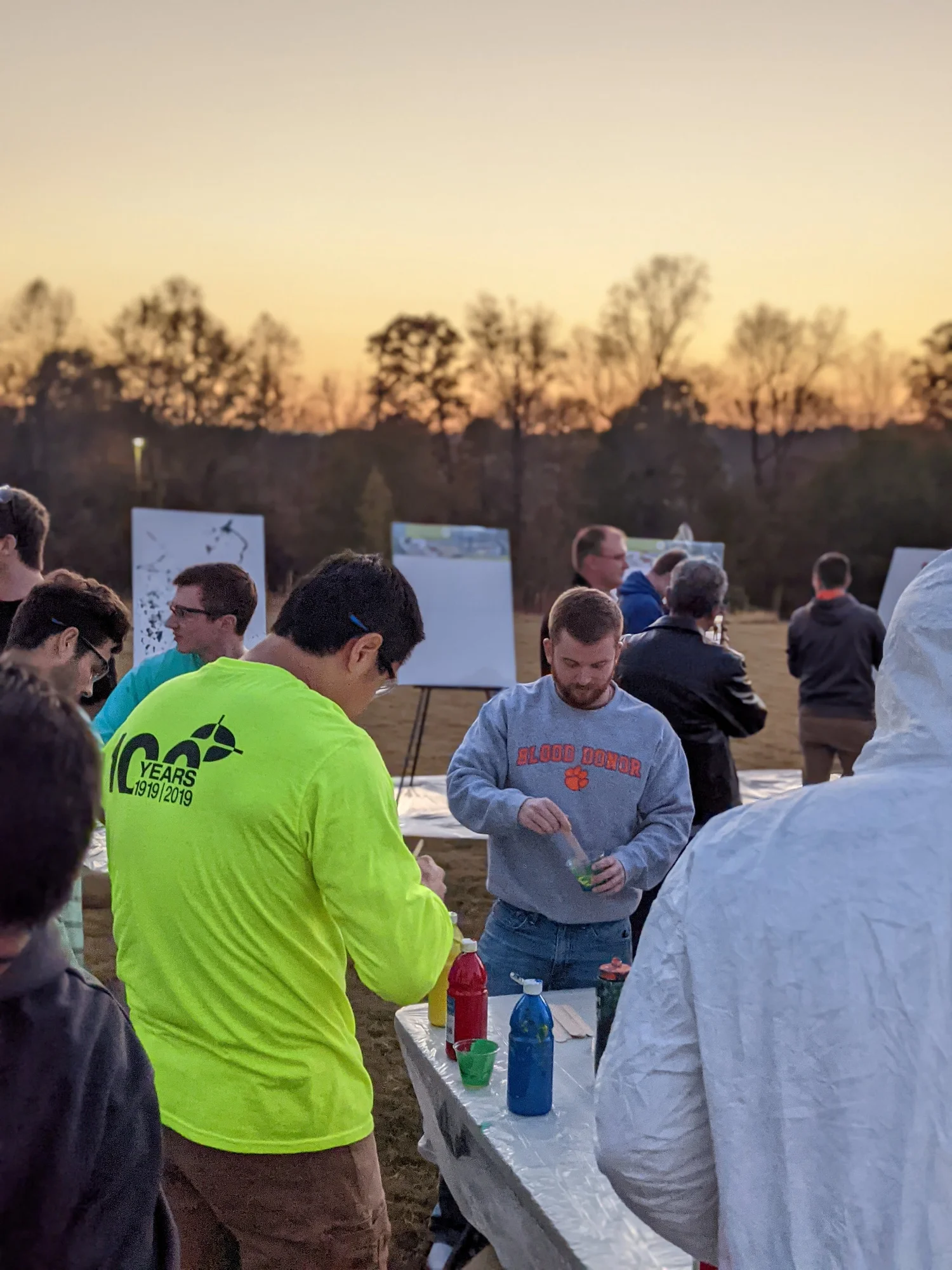 Mixing paint at a table outdoors at sunset.