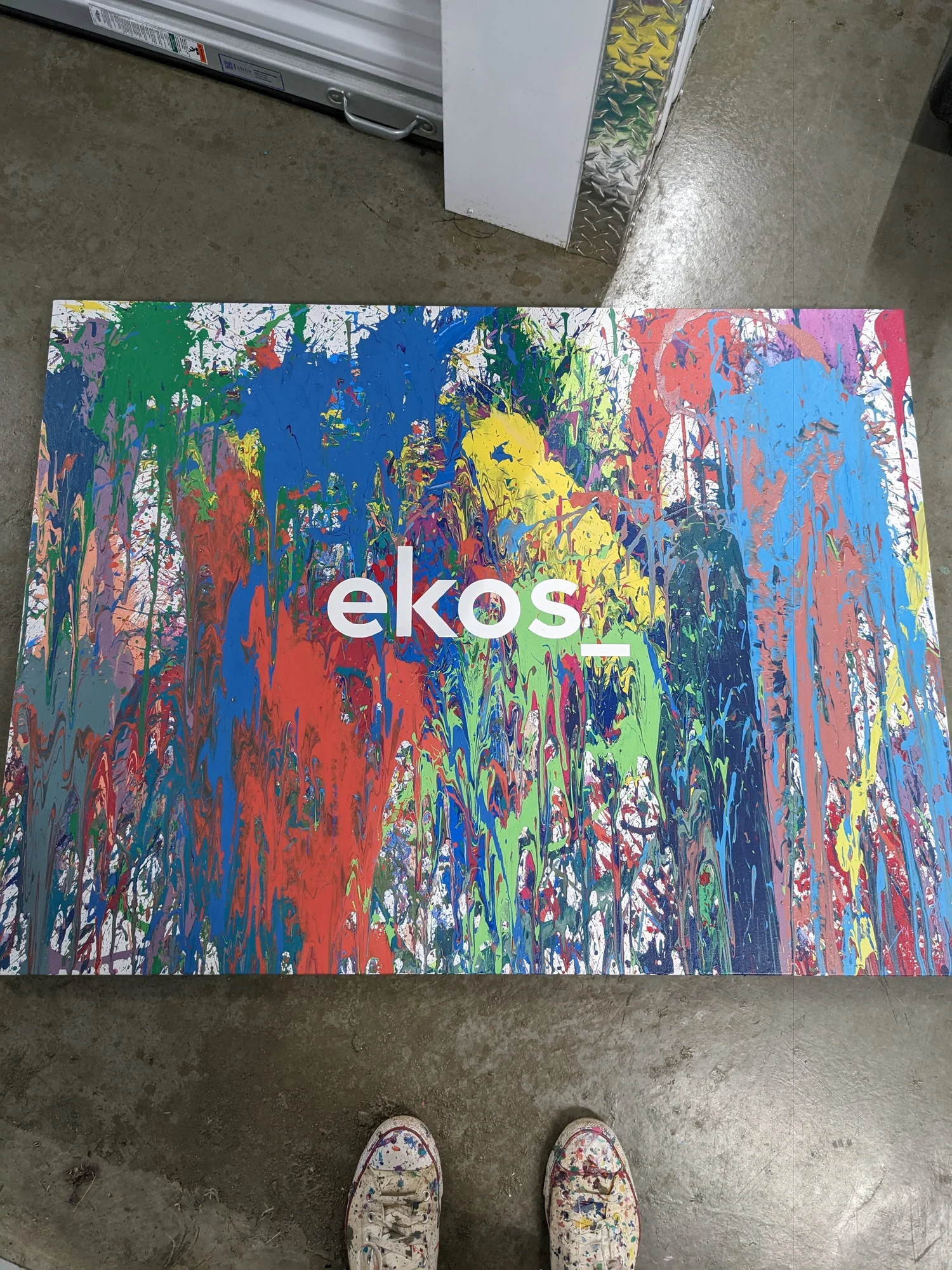 The Ekos wordmark showing through in unpainted canvas.