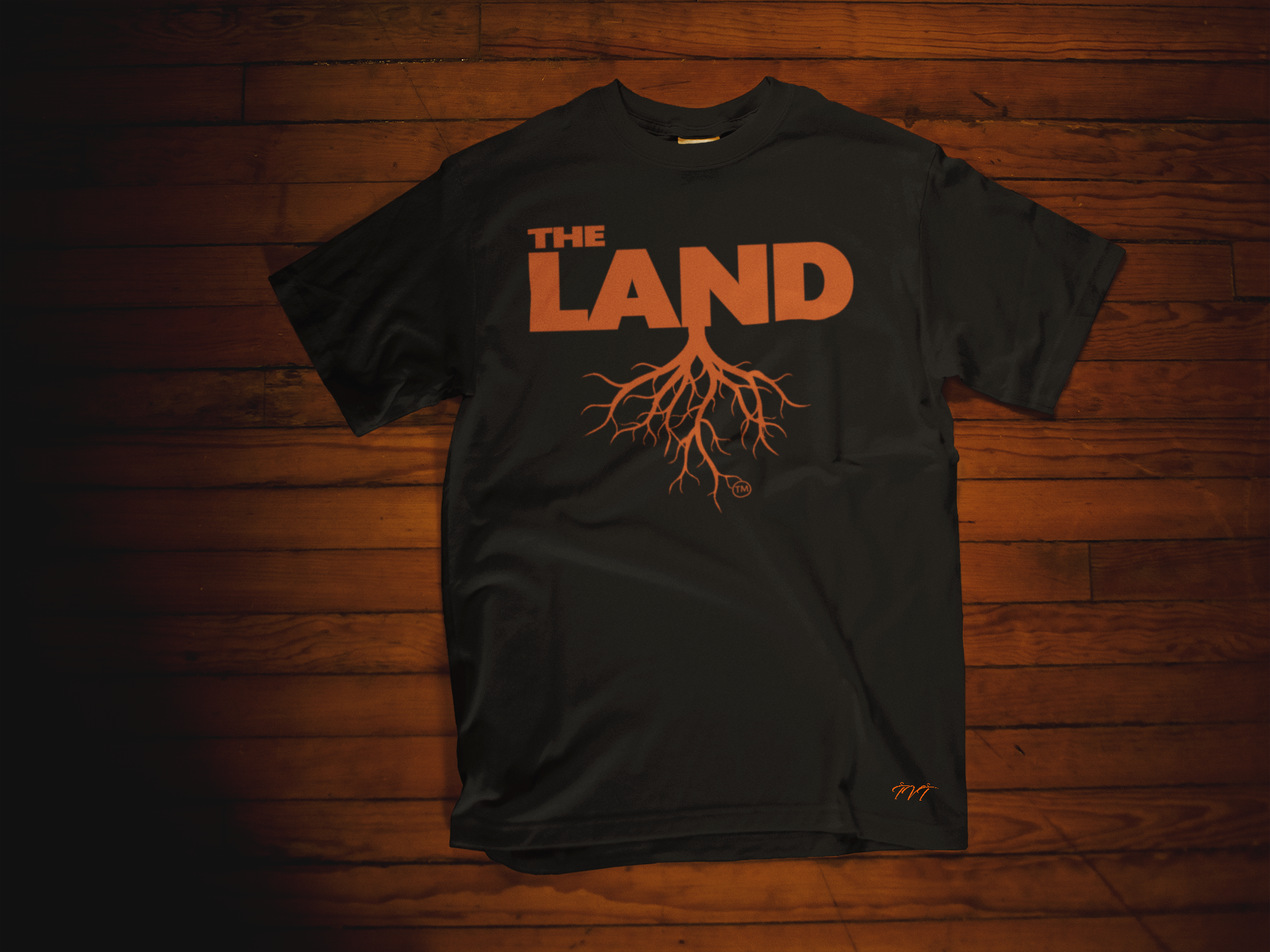 T-SHIRT MOCKUP OF THE LAND BLACK (NEON ORANGE) T-SHIRT LYING OVER A WOODEN SURFACE.png