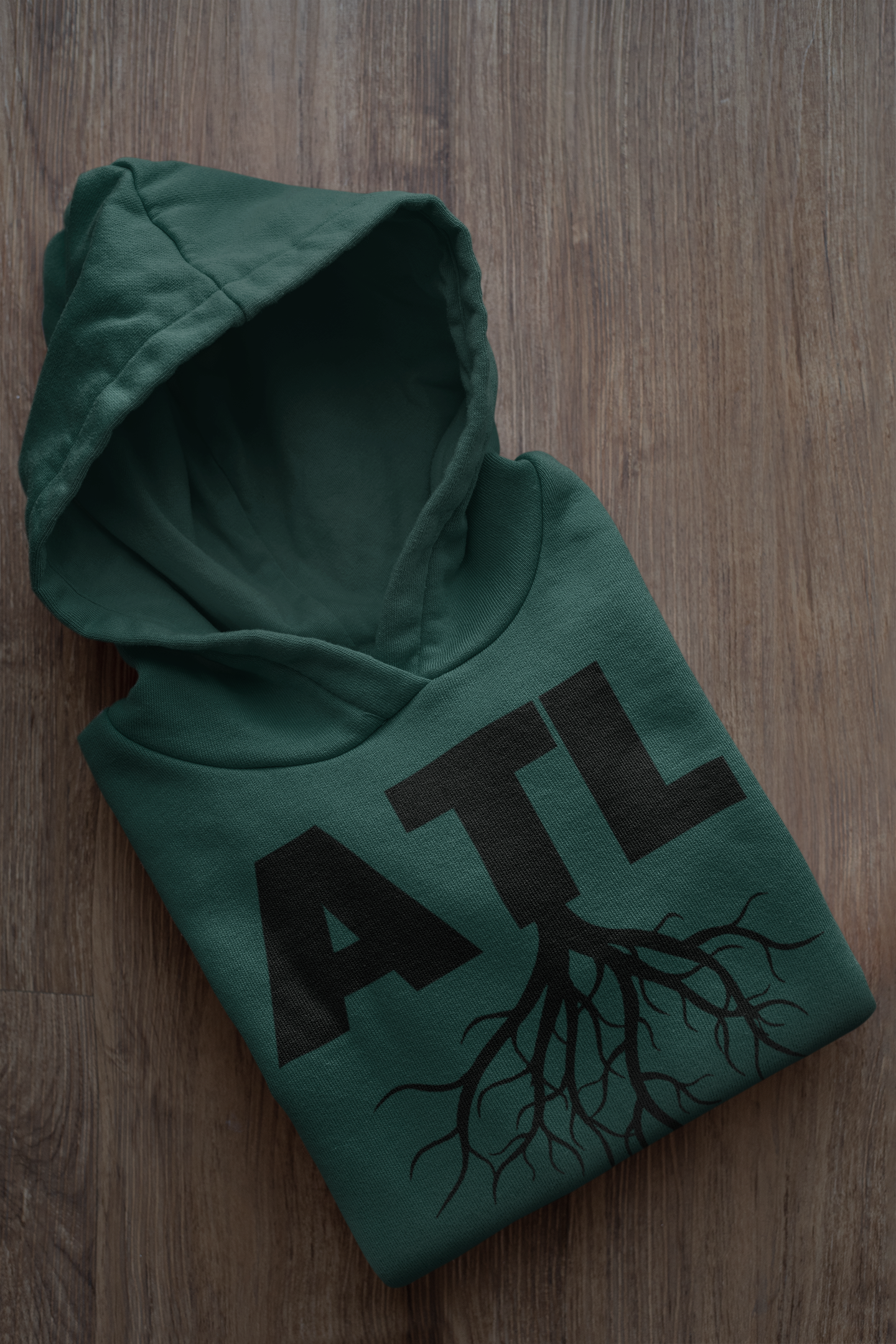 HOODIE MOCKUP OF A FOLDED ATL FOREST GREEN (BLACK) SWEATSHIRT HOODIE PLACED ON A WOODEN SURFACE.png