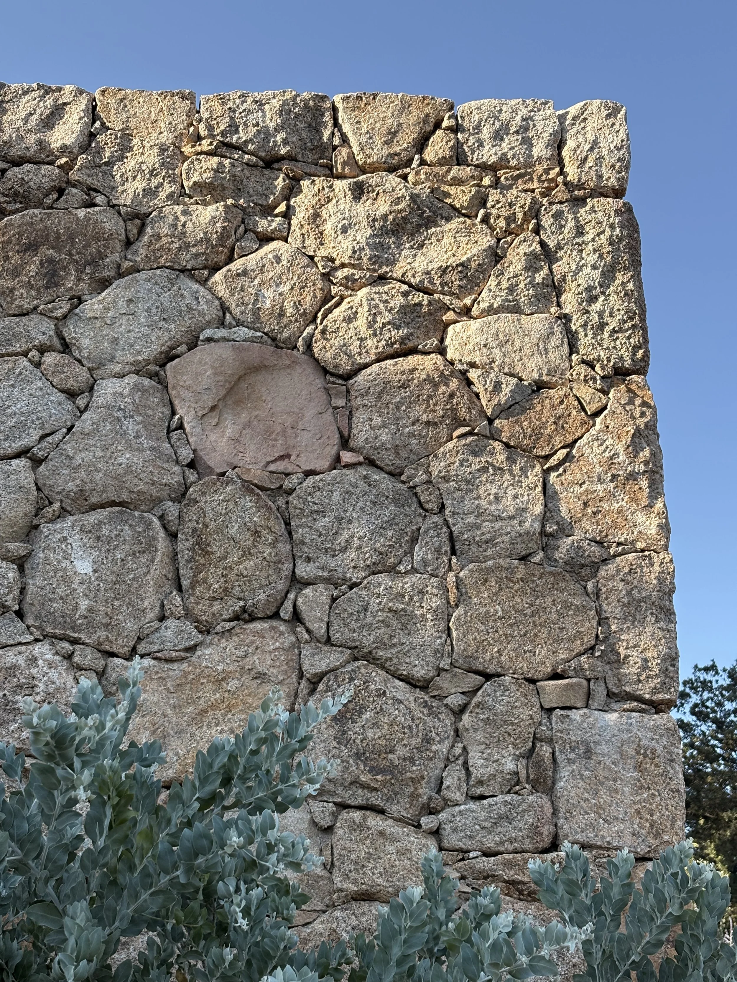 Façade contemporaine de Casavistu intégrée aux rochers de granit