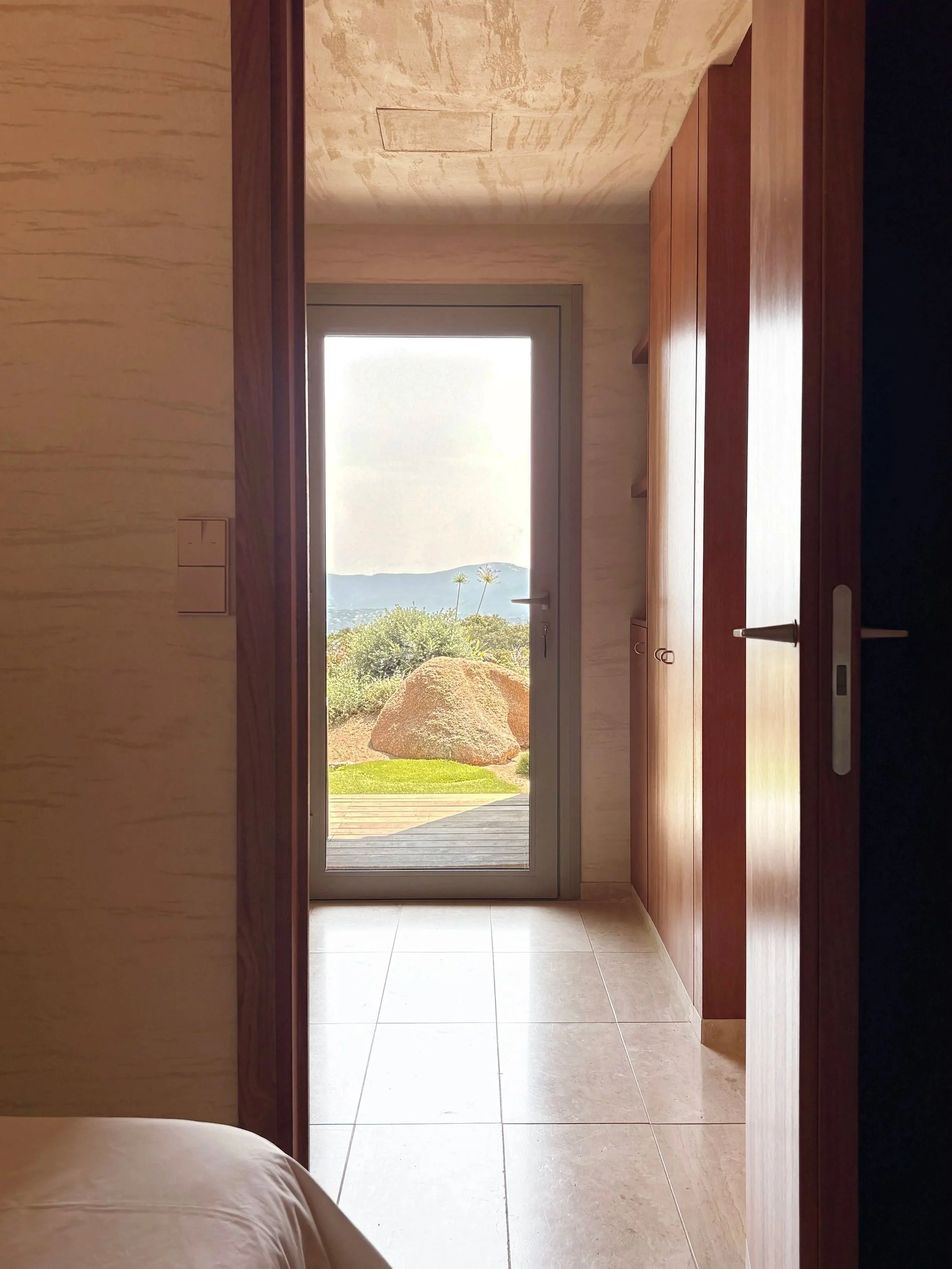 Couloir d’une chambre ouvert sur le jardin et la vue mer