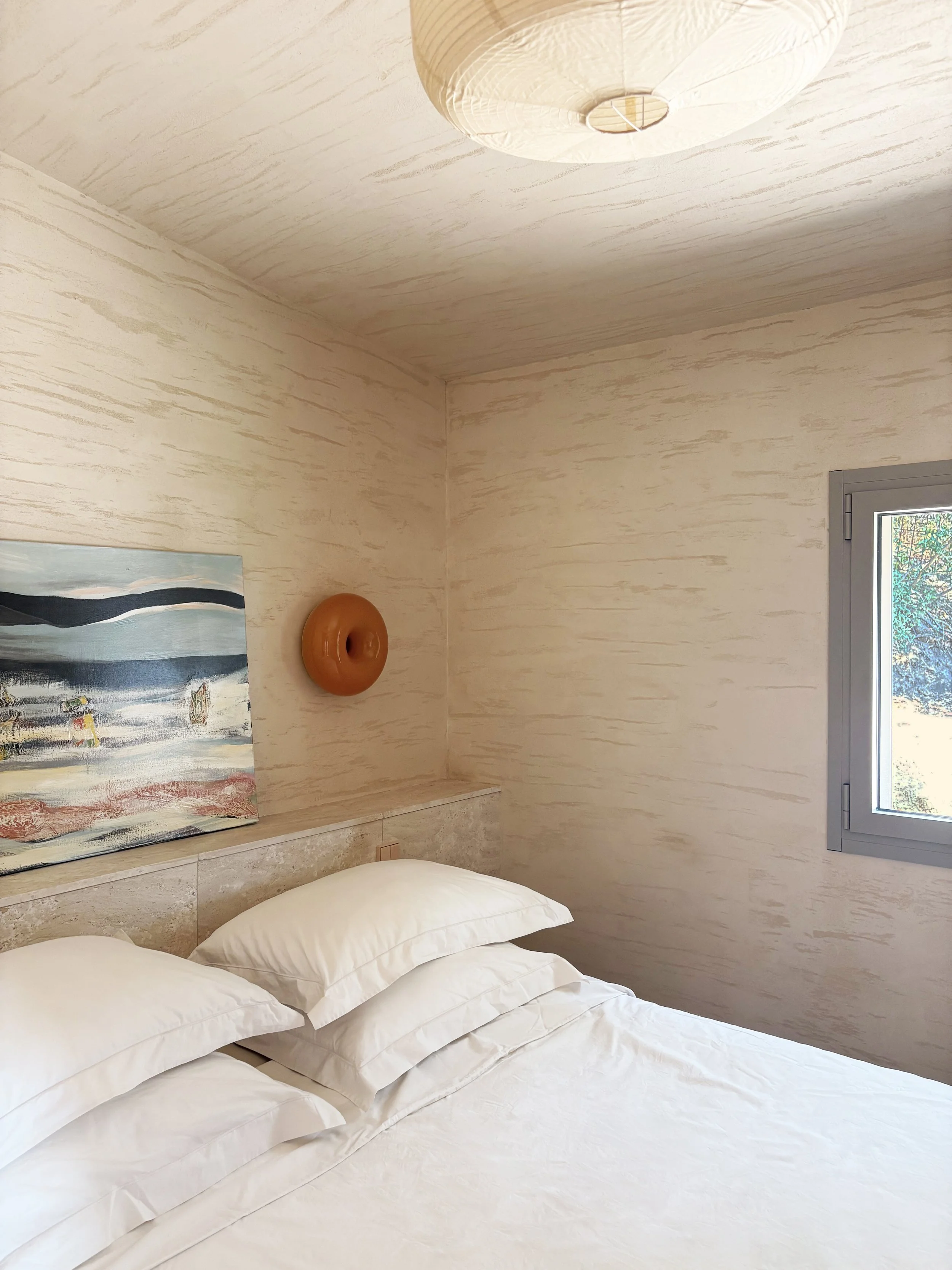 Chambre lumineuse avec lit double et fenêtre donnant sur le jardin