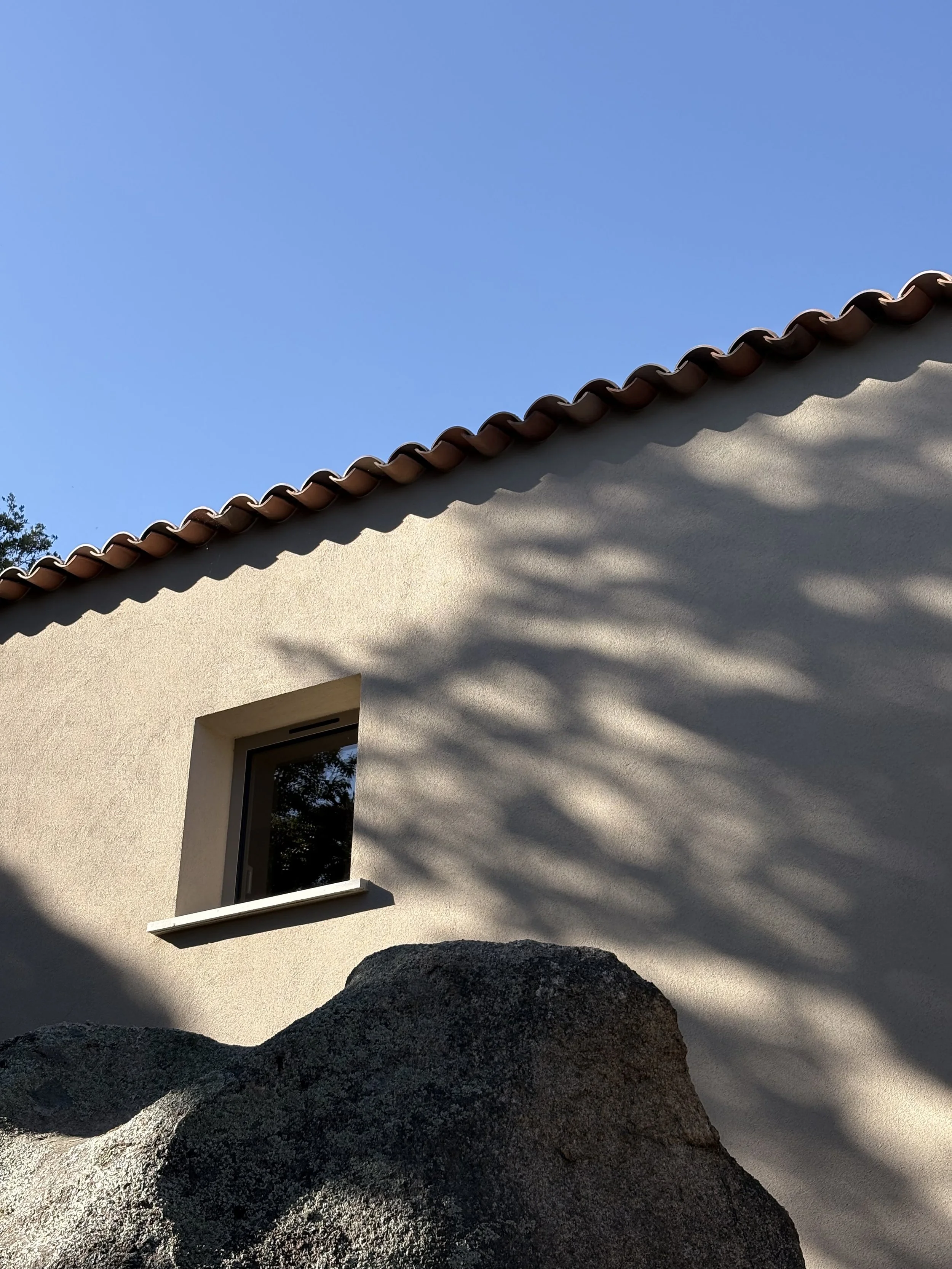 Façade contemporaine de Casavistu intégrée aux rochers de granitla vue mer