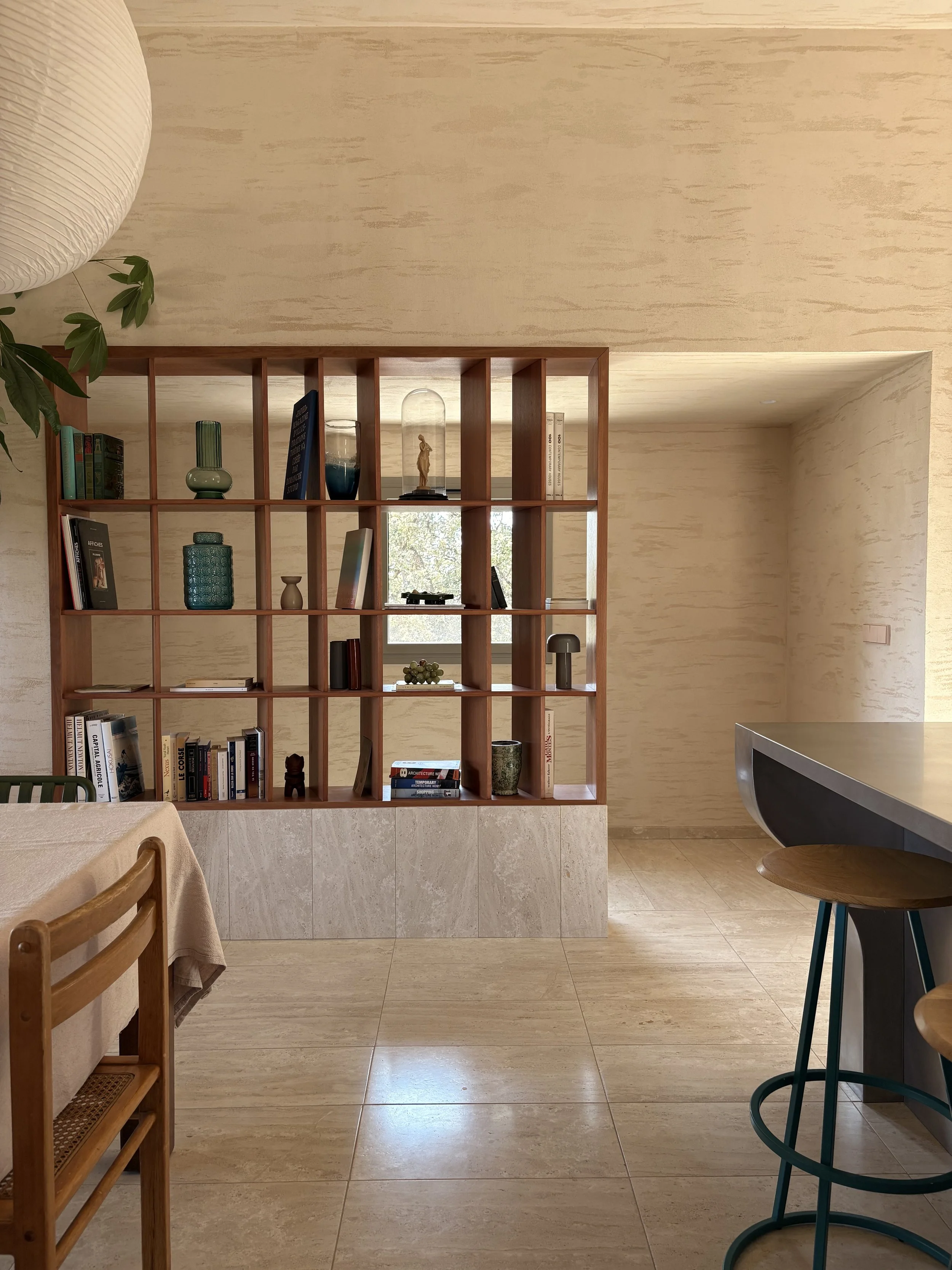Bibliothèque en bois séparant la salle à manger et la cuisine