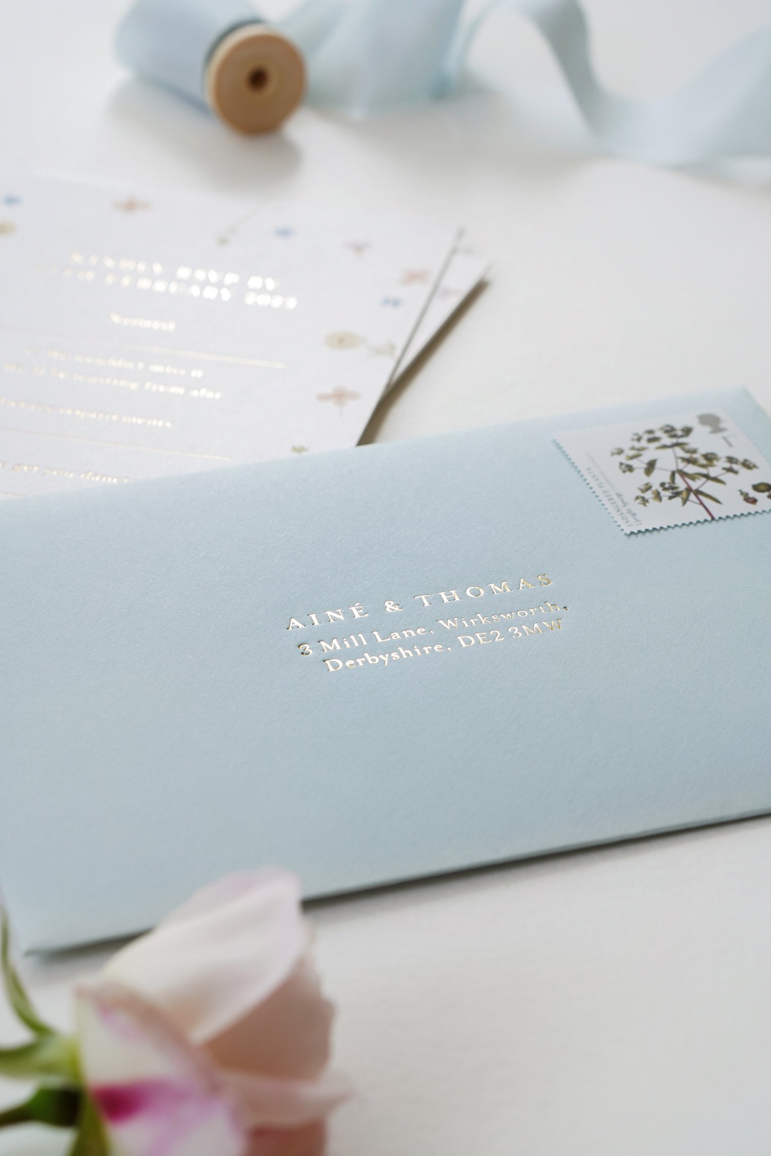 Pale blue envelopes with a gold foil RSVP address