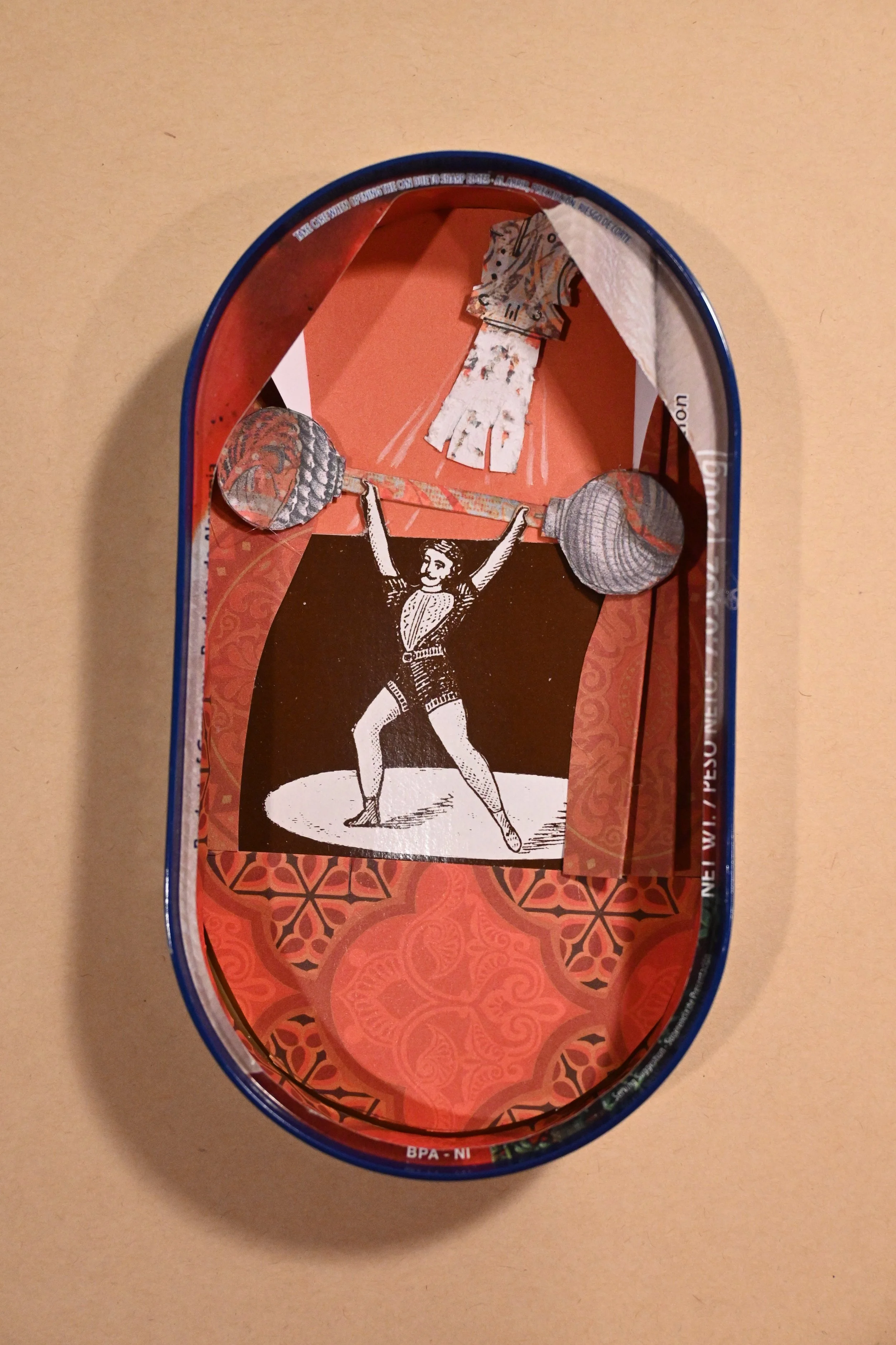 "Canned Strongman" (metal can, paper, ink)