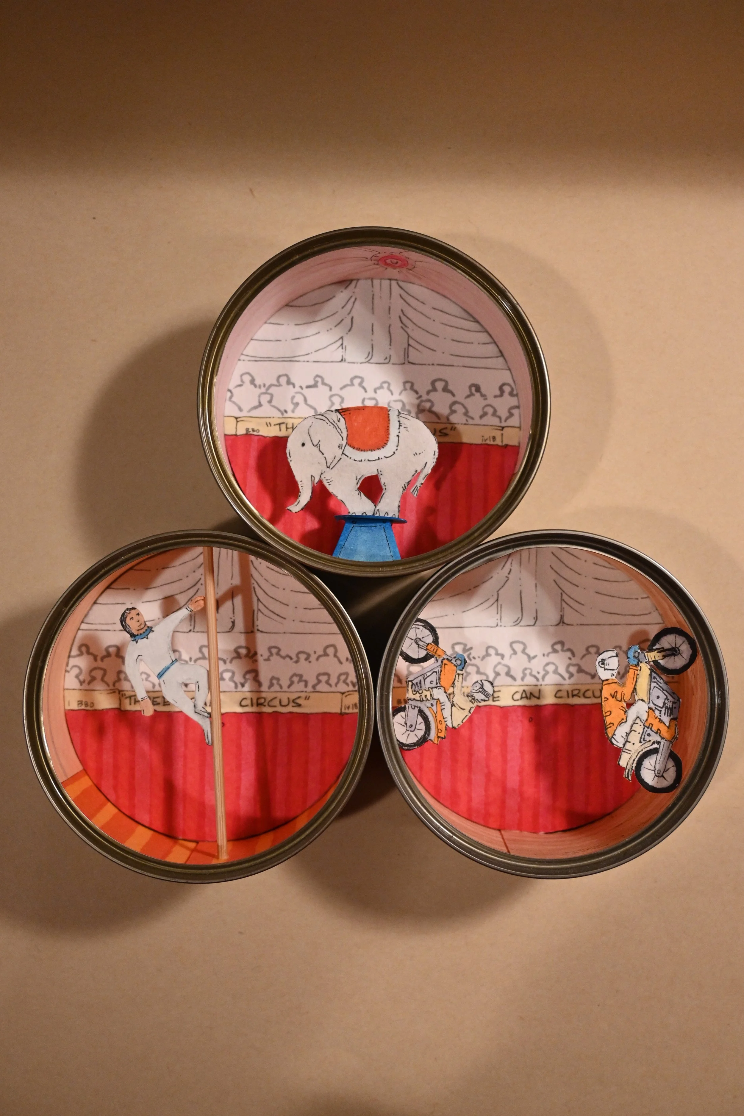 "Three-Can Circus" (metal can, paper, wood, ink)