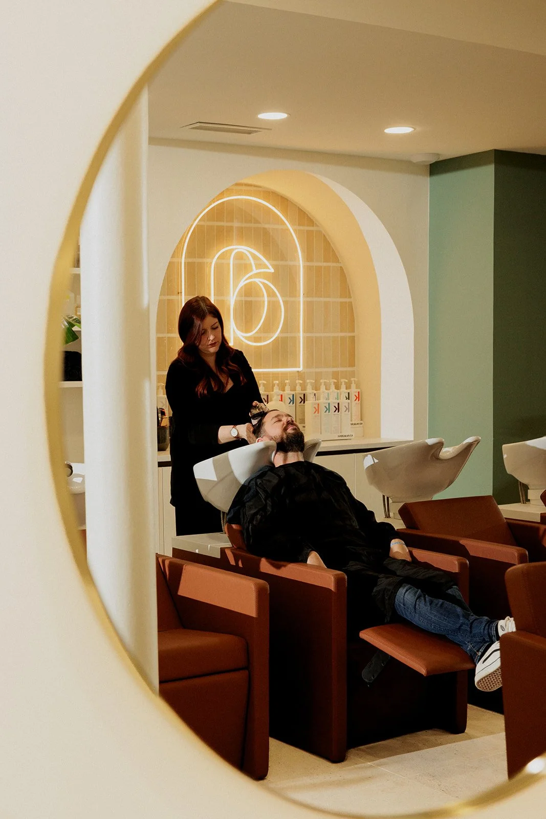 Un salon de coiffure où Arielle fait un shampoing à un homme