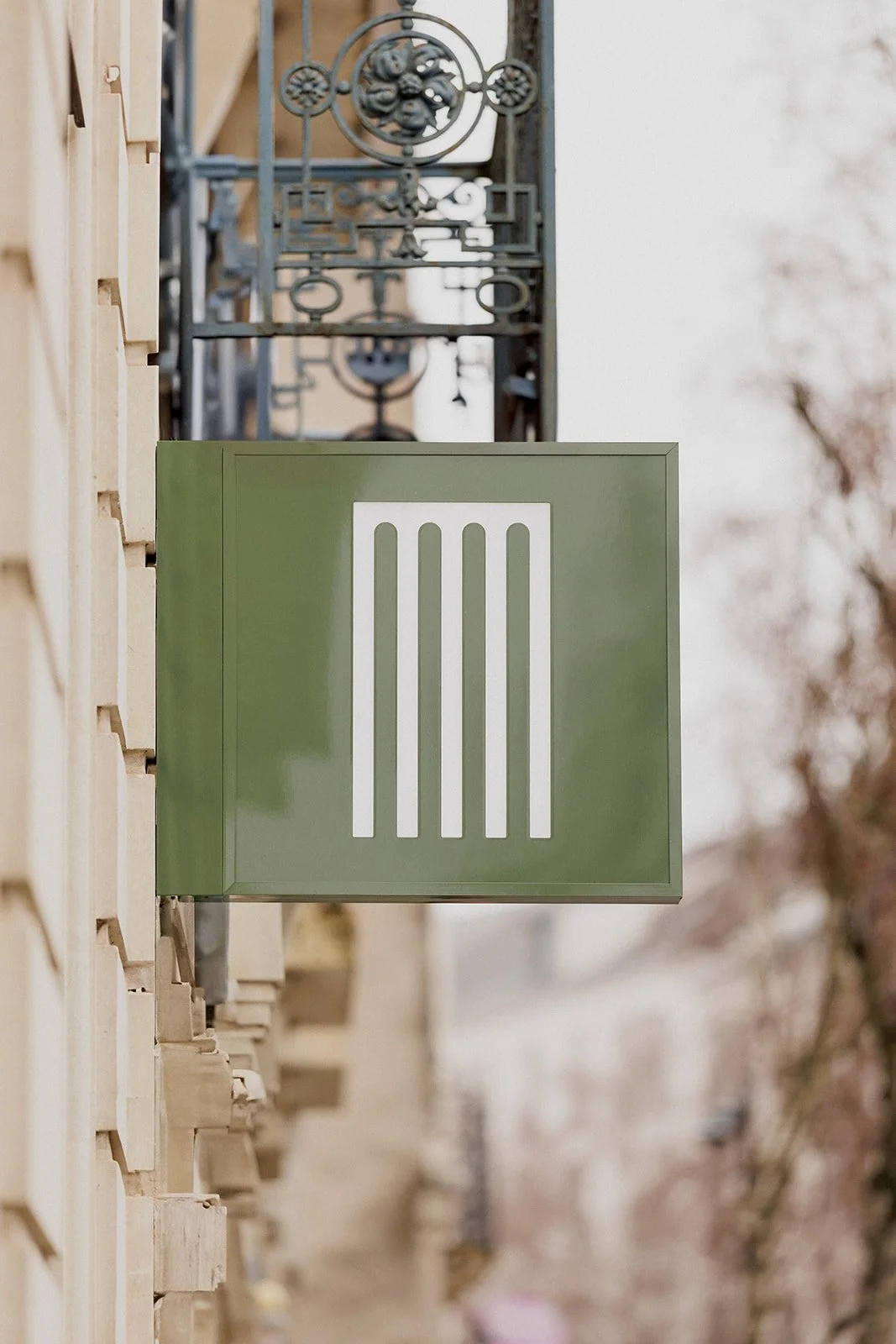 Enseigne drapeau extérieure verte du salon Arielle avec le symbole du peigne