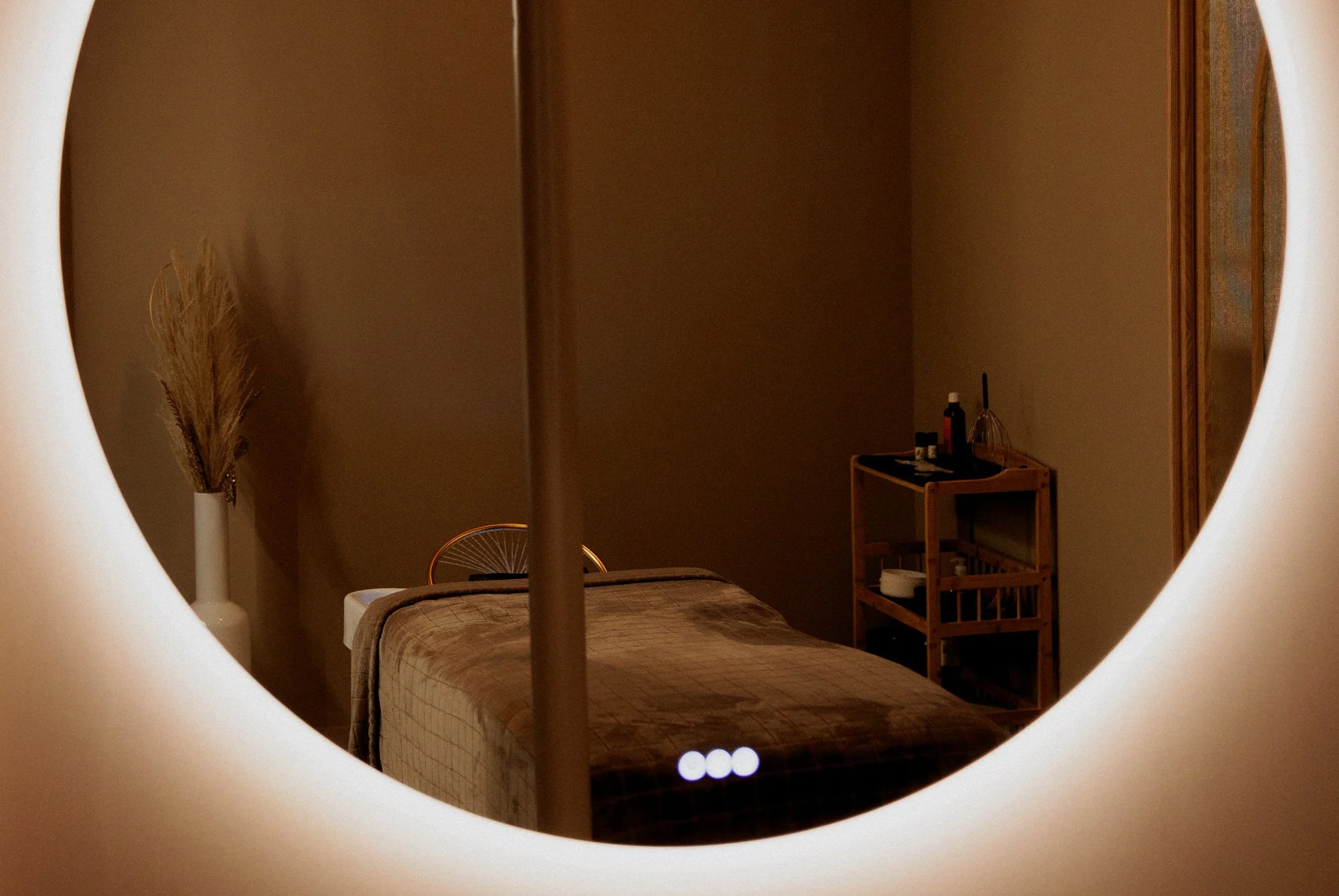 Table Head Spa avec son matelas vus dans un miroir LED rond