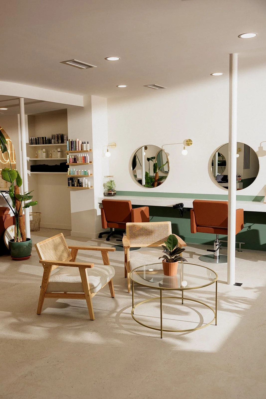 Vue intérieure du salon de coiffure, avec l'espace d'accueil, les postes de coiffage 