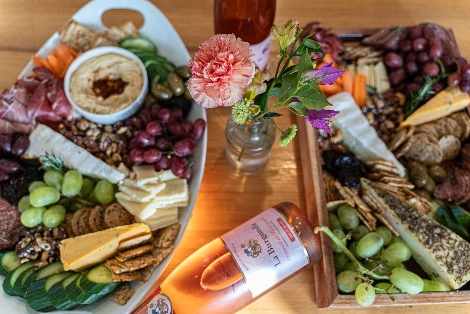 colorful lay flat overhead shot of charcuterie, flowers, and rose wine for a retreat welcome dinner by photographer Lenee Love
