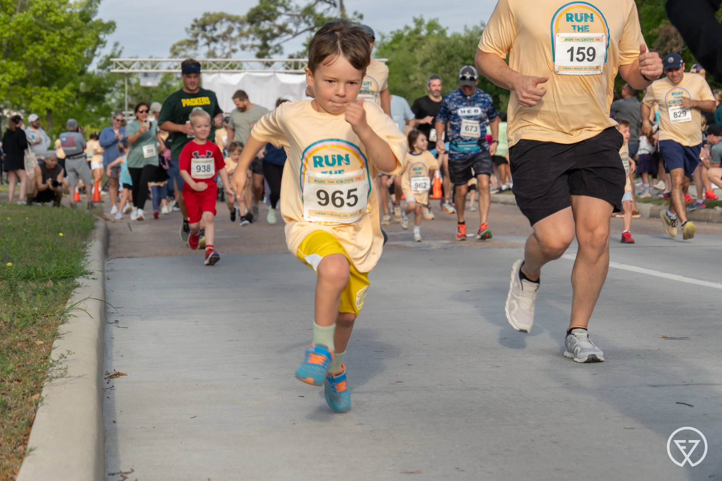 kid running full speed at the head of a crowd during run the grove 5k by fitness photographer Lenee Love