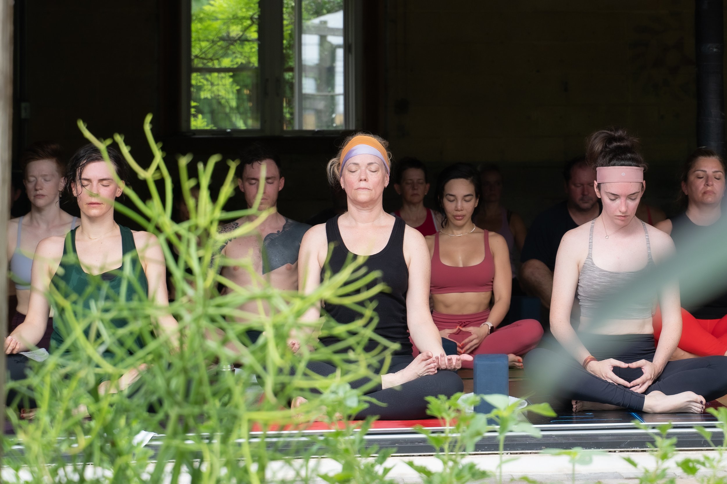 room of sweaty yoga students meditating by photographer Lenee Love