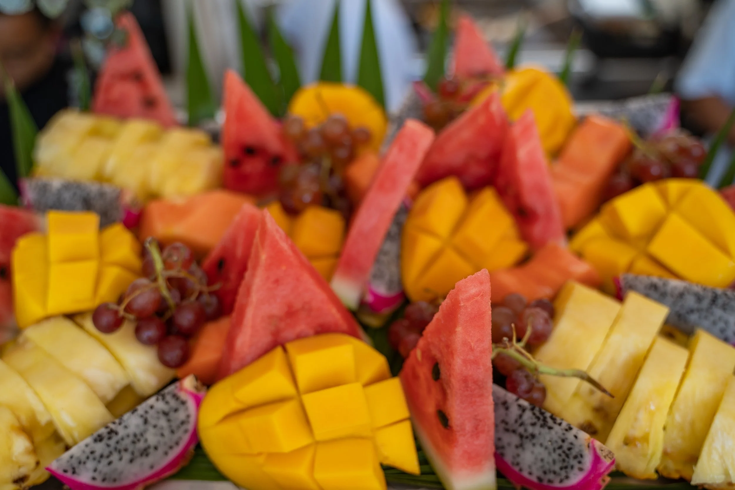tray of vibrant cut fruit mango watermelon grapes dragonfruit by photographer Lenee Love
