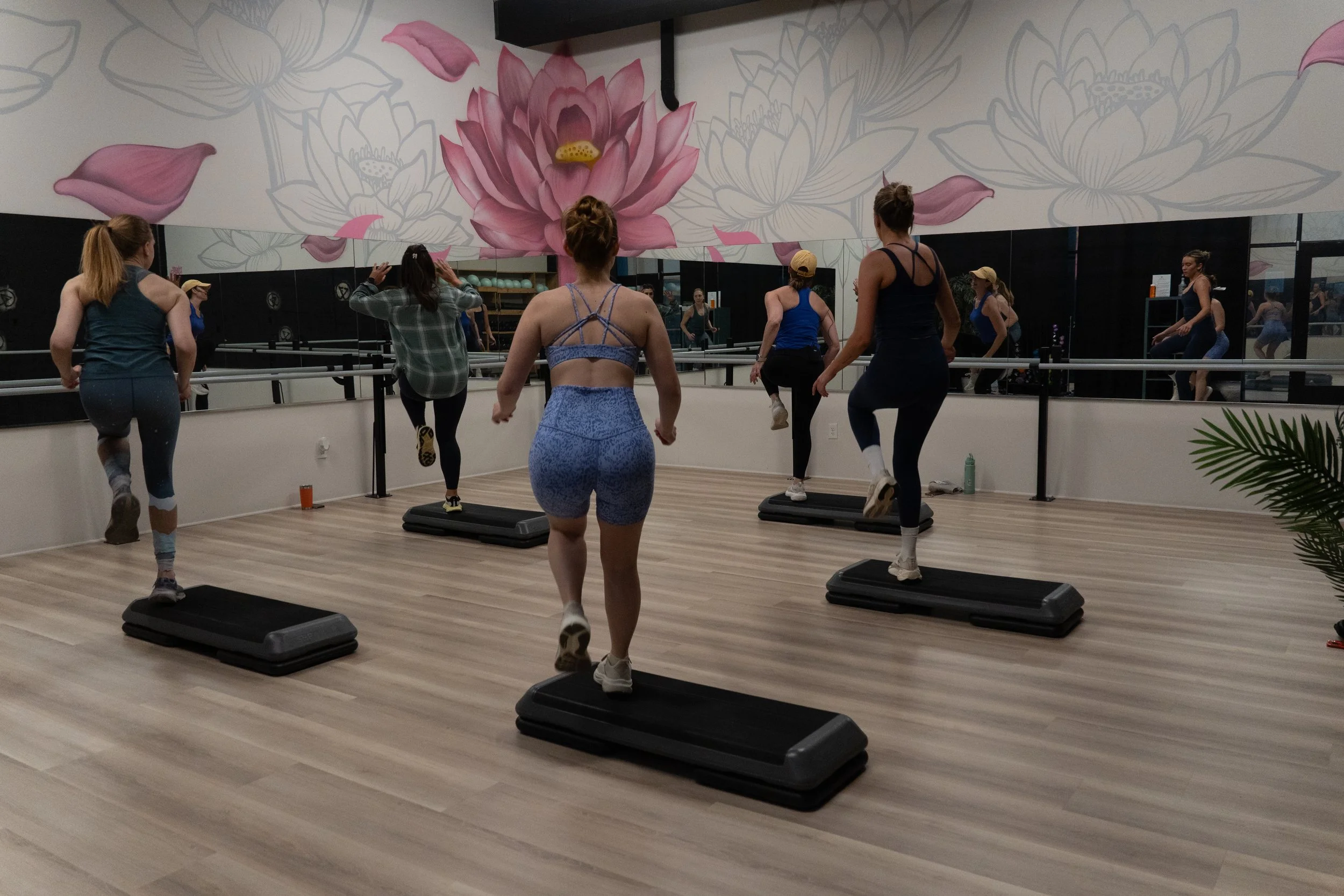 five women in a step class in sync at a gym by photographer Lenee Love