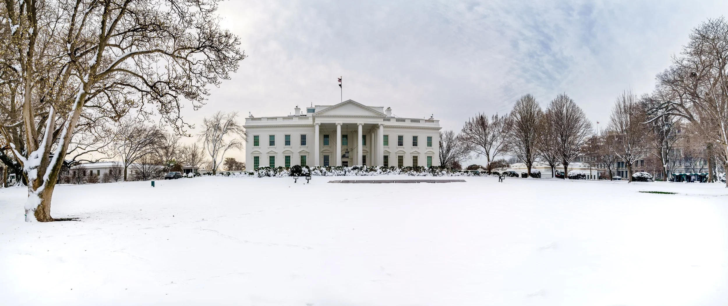 A panoramic shot of The White House in snow. 