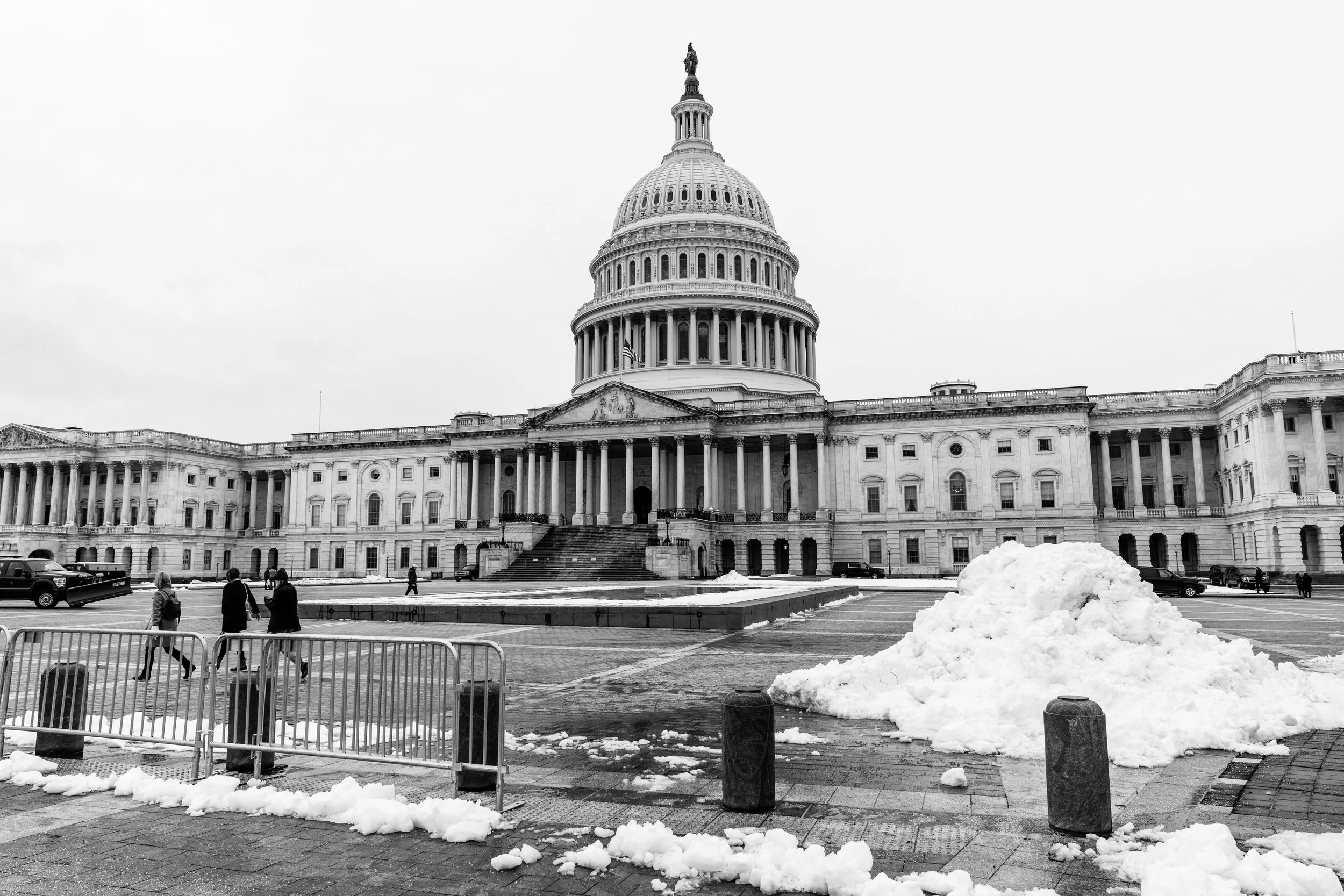A black and white image of the U.S. Capitol's front side.