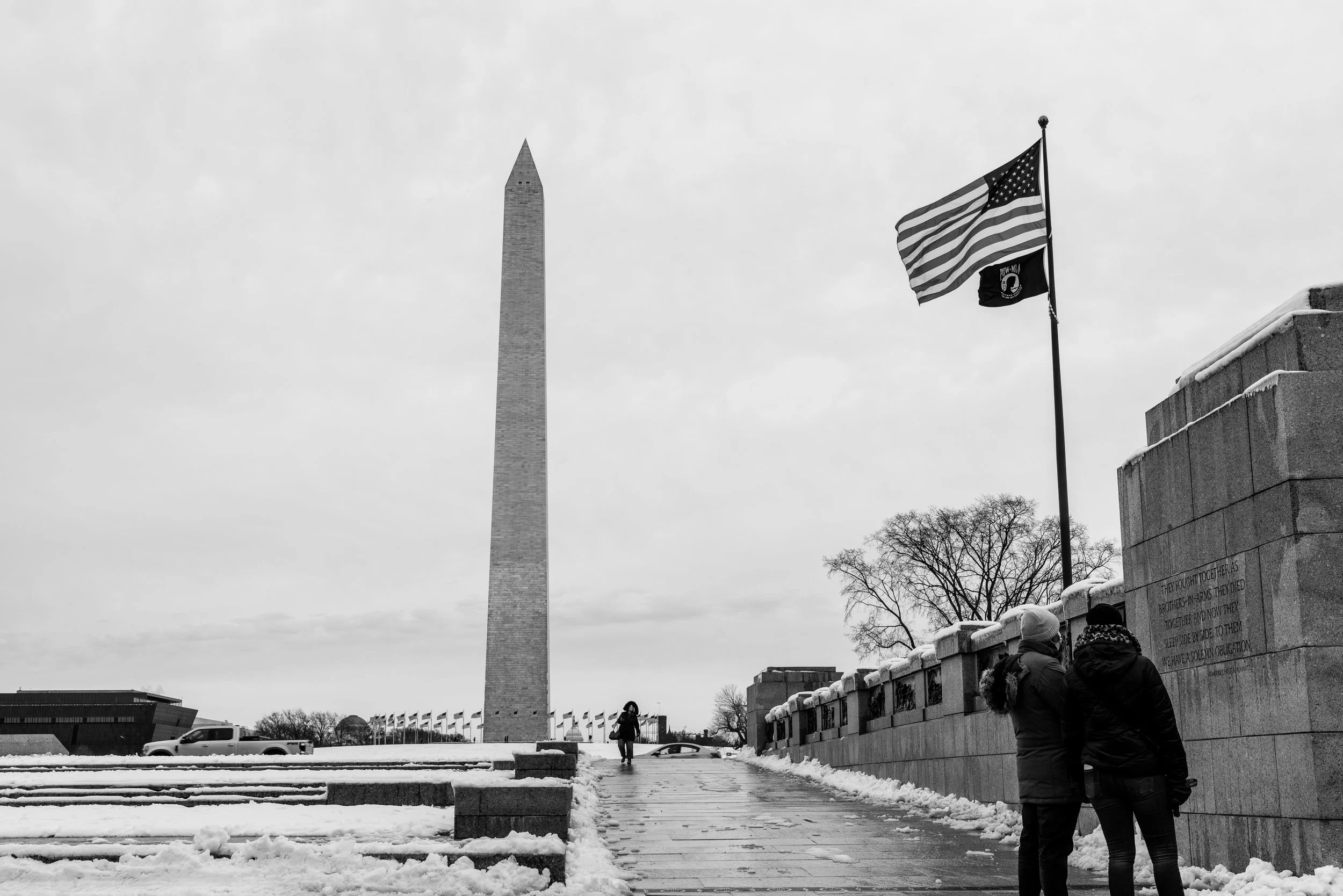 A black and white shot of the George Washington monument from the World War II monument. 