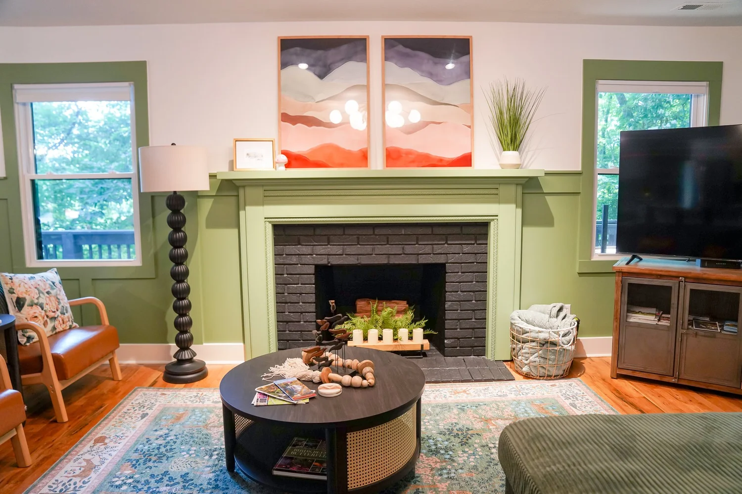 The Fernwood living room with a sage green fireplace and mountain art