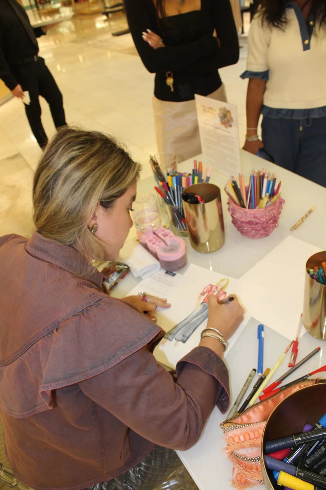 Amanda Perna drawing a live fashion illustration of a guest at Neiman Marcus