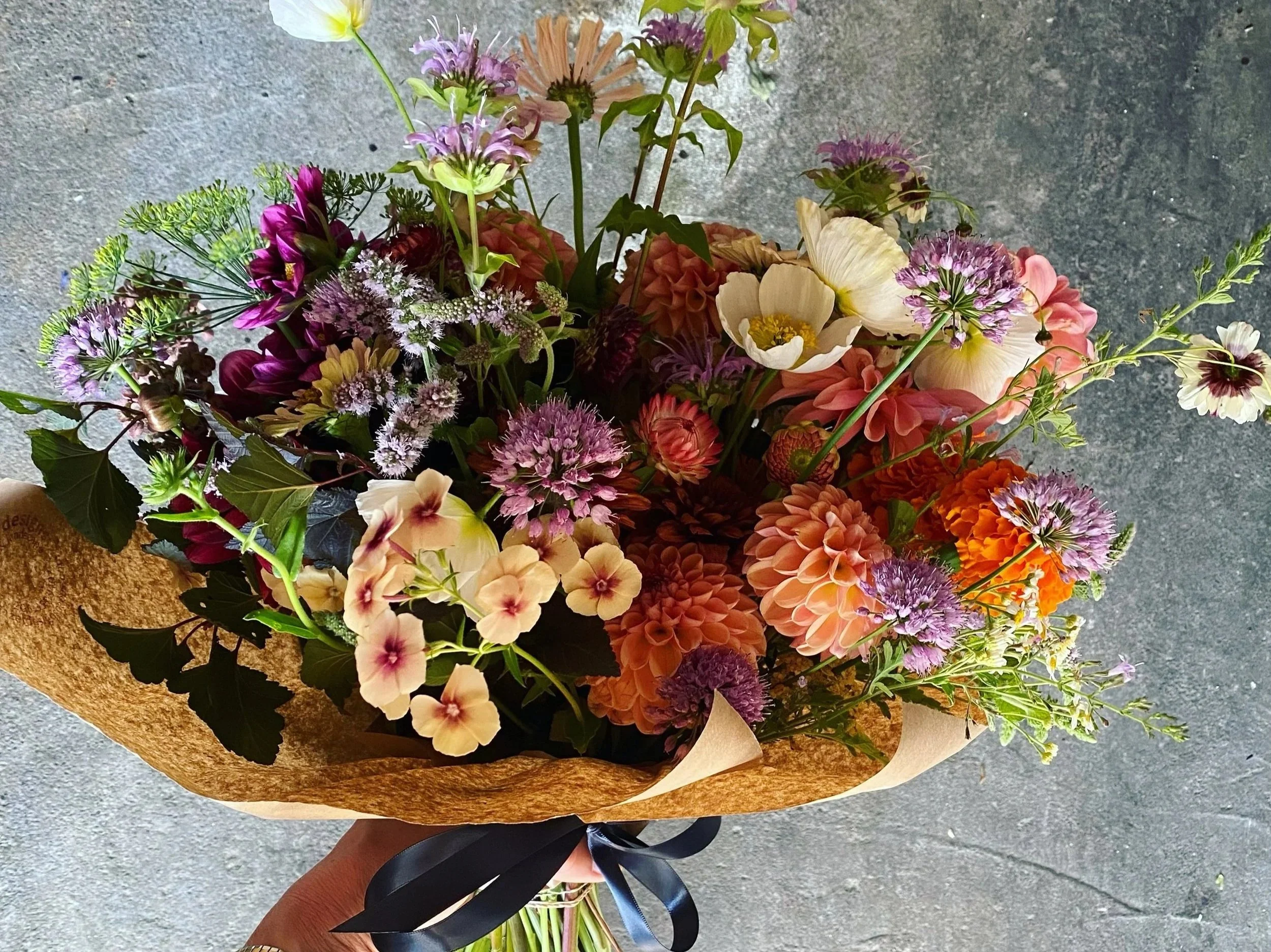 beautiful seasonal locally grown flowers in a wrapped hand tied bouquet