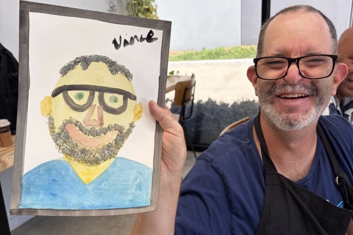 Leisure Networks artist holding his painted self-portrait at The Light Box Torquay