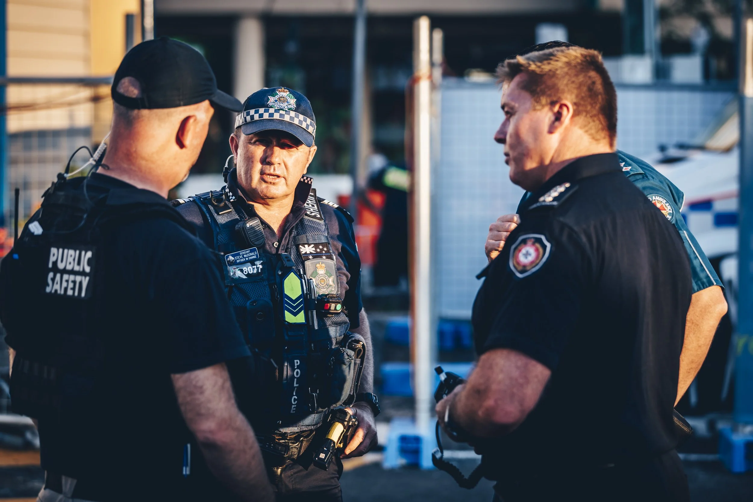Group of police officers in uniform having a discussion outdoors.