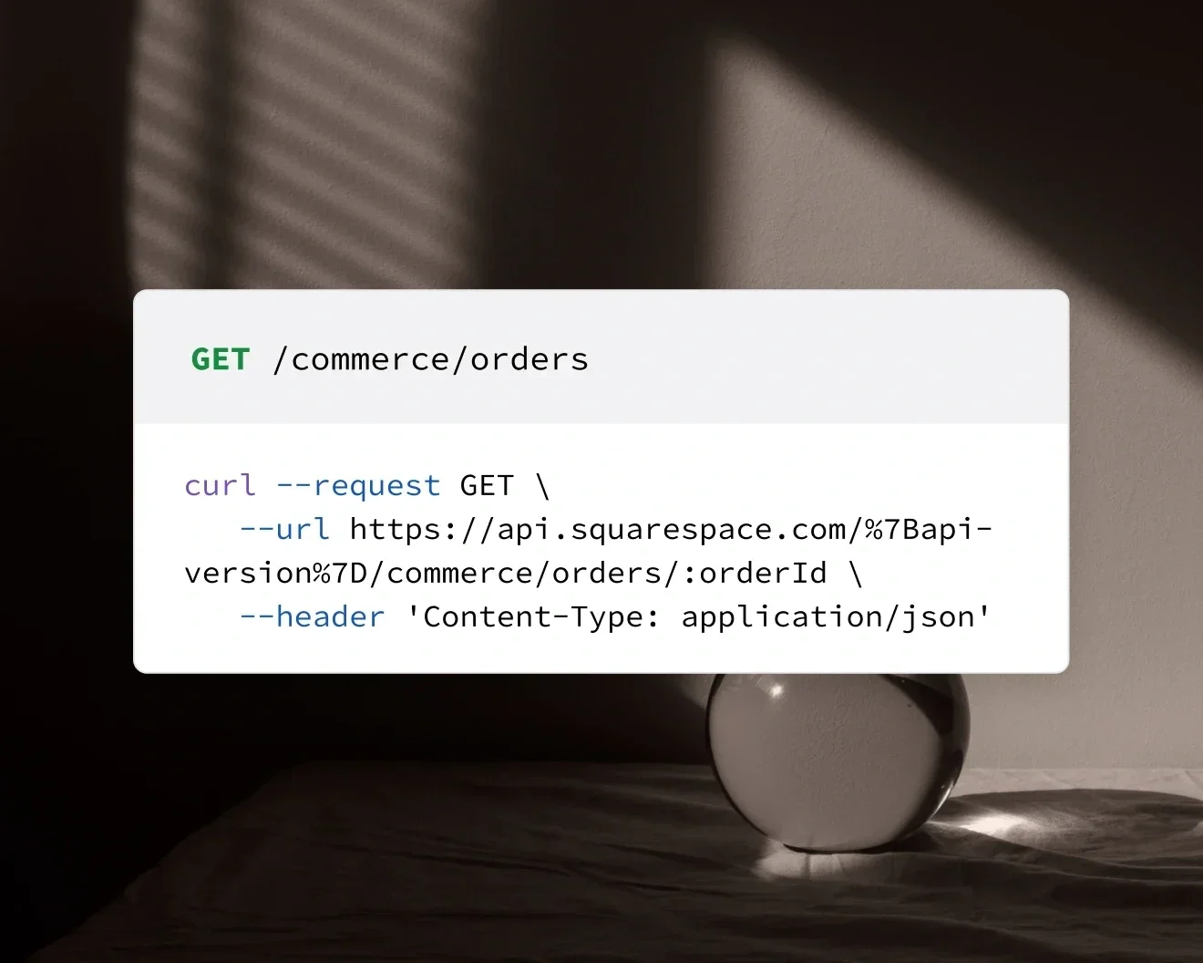 Computer screen displaying a command line curl request to the URL https://api.squarespace.com/... for getting orders from an API, with natural light casting shadows through blinds onto a surface.