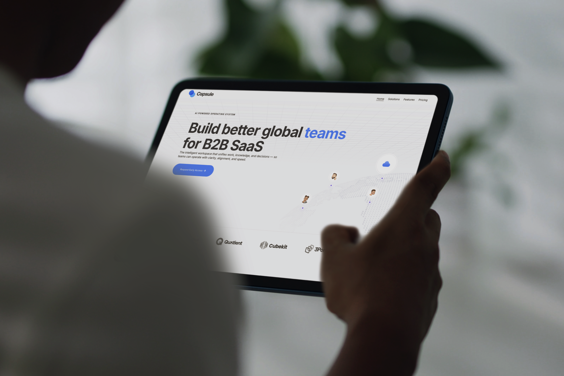 Person holding a tablet displaying a website for building global teams for B2B SaaS