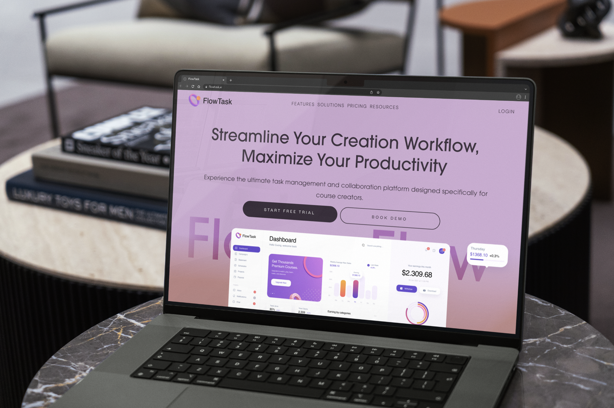 Laptop on marble table displaying FlowTask website with a pink and purple interface promoting workflow management software.