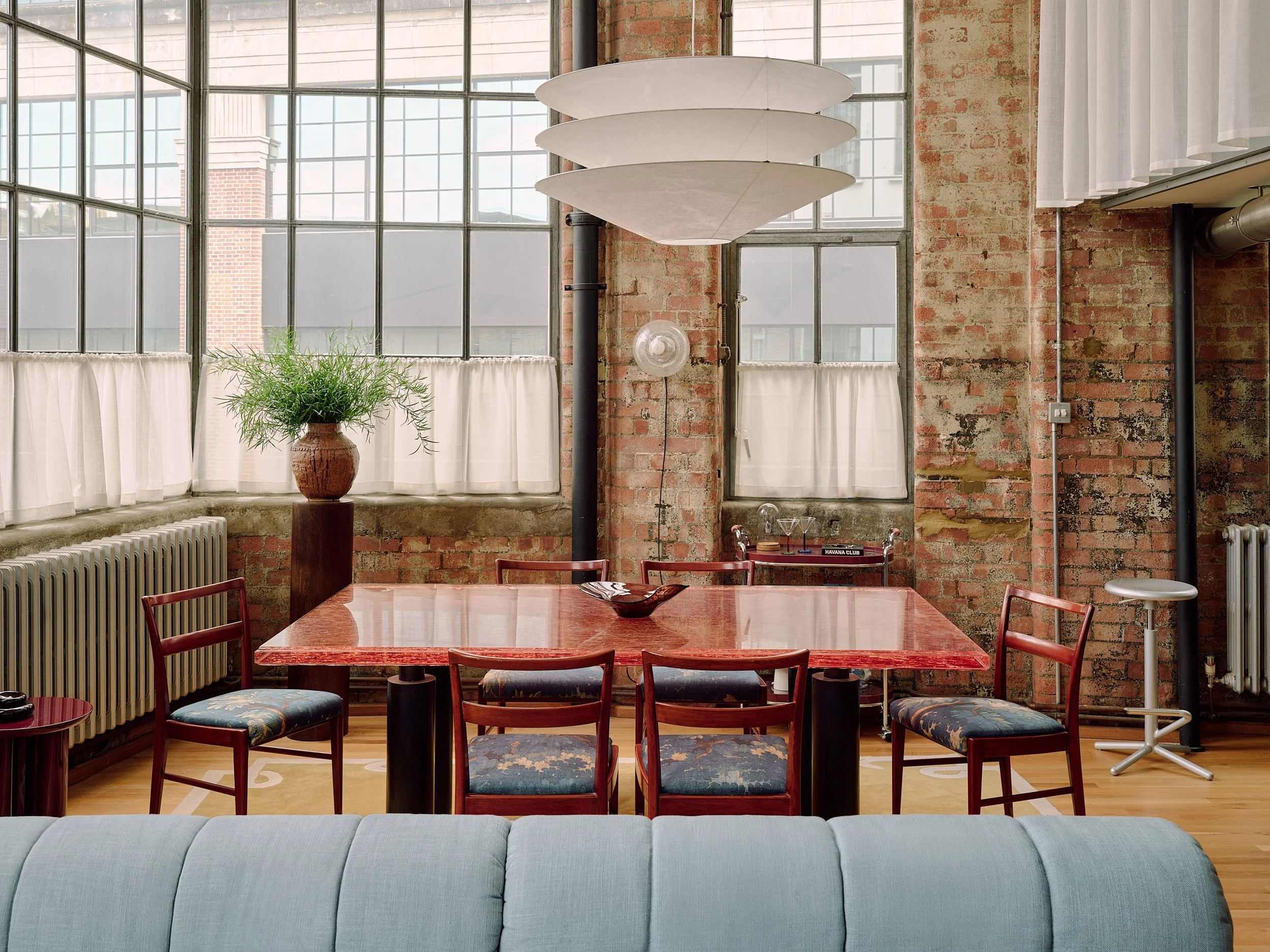 Retro dining room with exposed brick, Ingo Maurer pendant and vintage glass wall lights in Farringdon loft, London interior design by Duelle