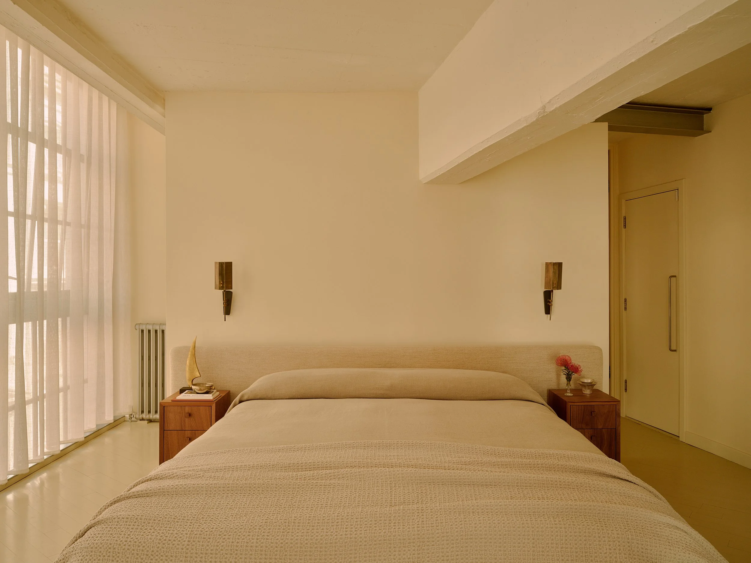 Calm master bedroom with off-white palette, linen wave curtains and beige linen bed in Farringdon loft, London interior design by Duelle