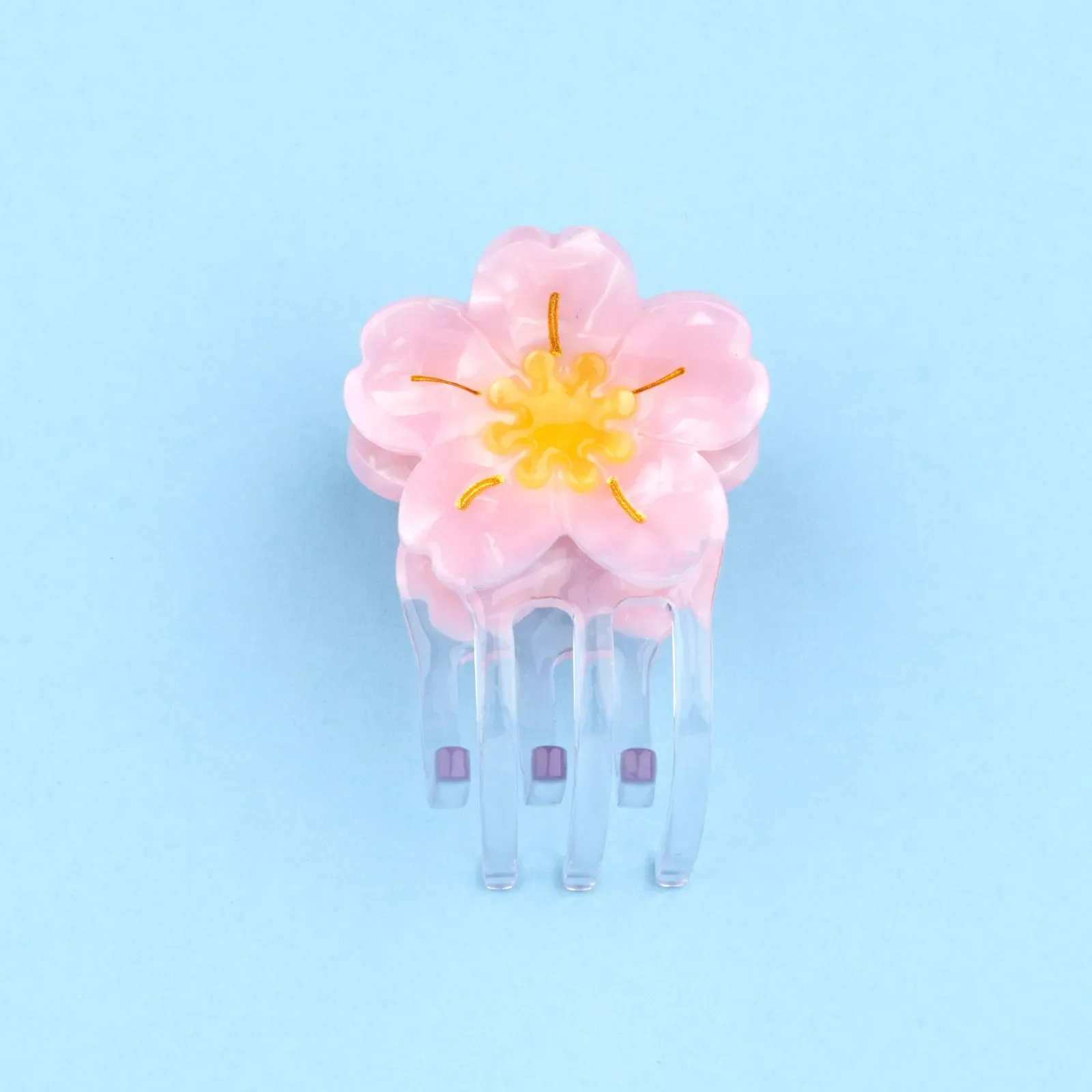 Coucou Suzette Mini Sakura Hair Claw in glossy cellulose acetate, a delicate French flower hair accessory curated by Goosebump.