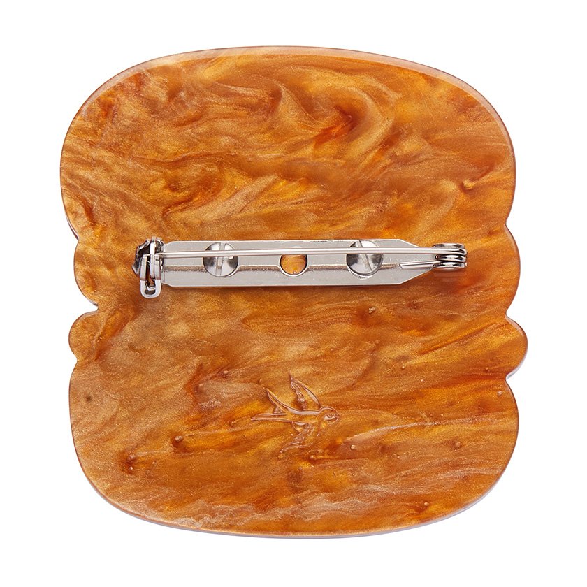 The Great British Scone Brooch, featuring a layered scone design with caramel and pearl resin details, from Erstwilder’s London Calling collection.