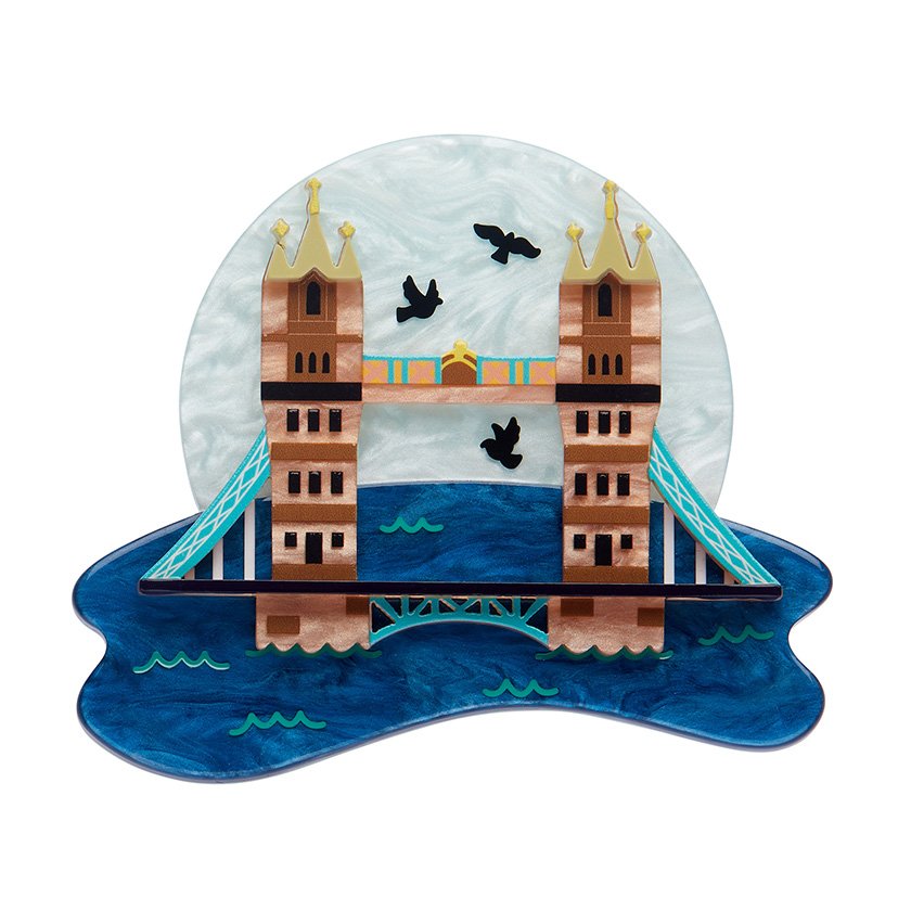 Tower Bridge Brooch featuring shimmering blue and gold resins, hand-assembled in a detailed design, perfect for London enthusiasts and accessory collectors.