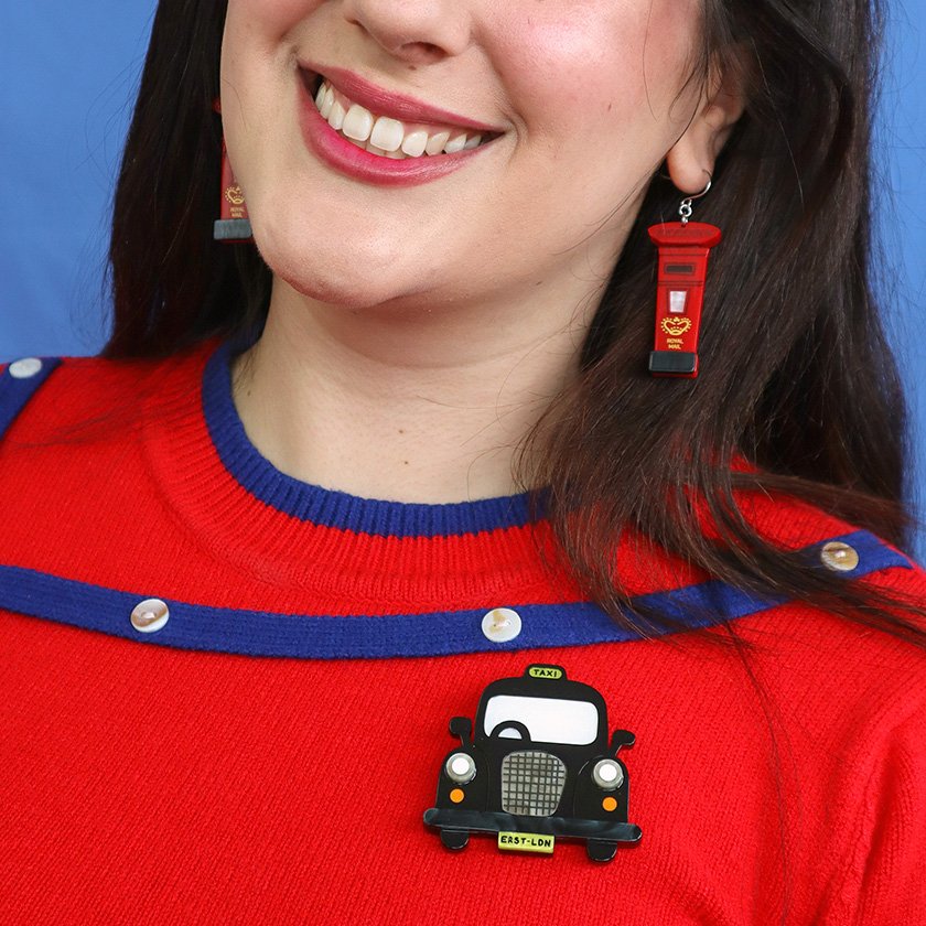 Handcrafted Black Cab Brooch featuring glossy black and glitter white resins. A stylish tribute to London taxis, part of Erstwilder’s London Calling collection.