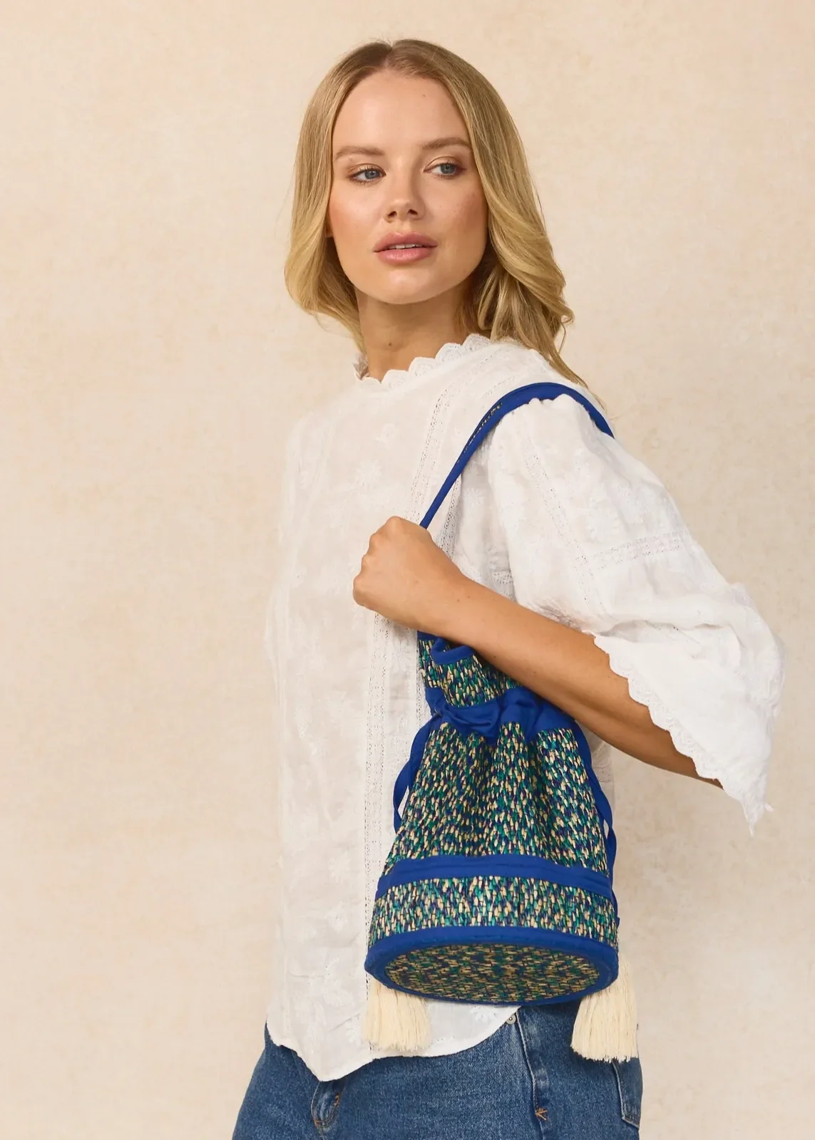 Model wearing the Lorna Murray Skyline Mini Leisure Tote as a crossbody bag, showcasing its detachable woven handle and long shoulder strap.